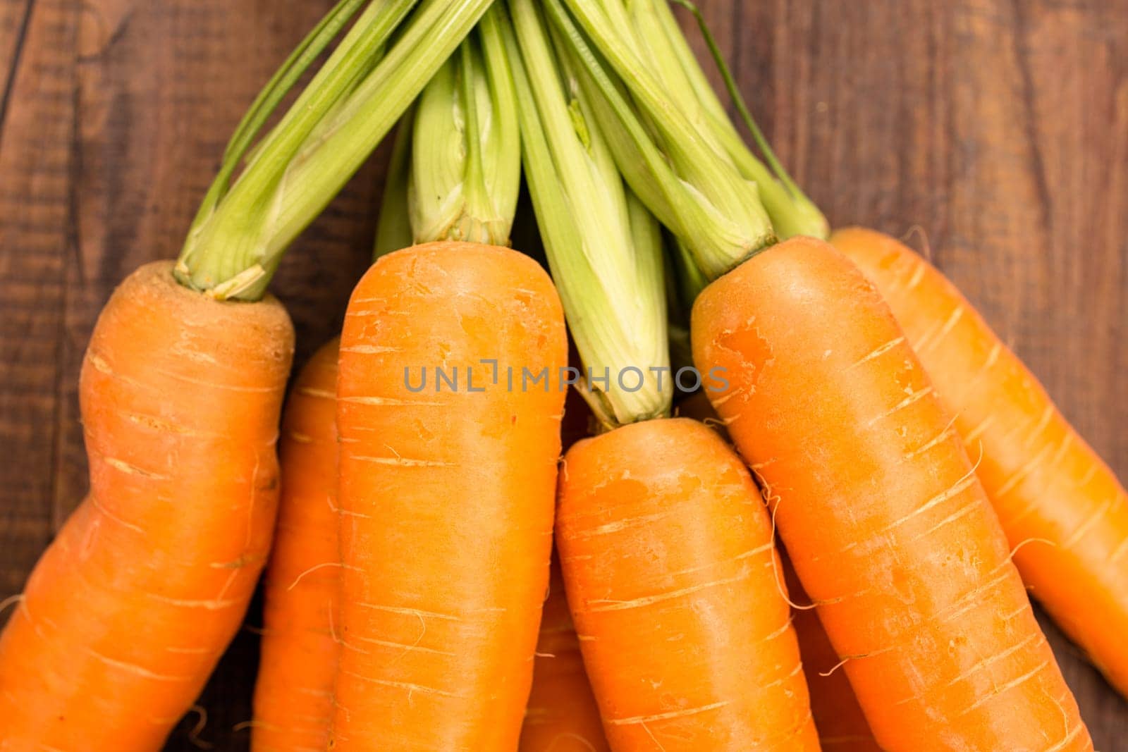 Carrots with green on wood