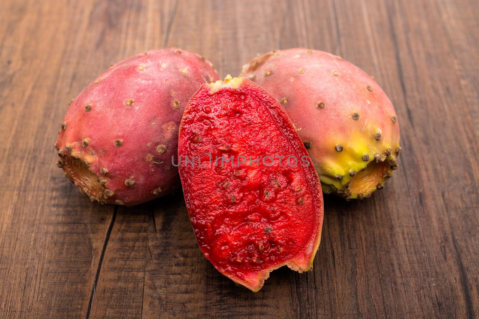 Red cactus fruit with seeds on wood