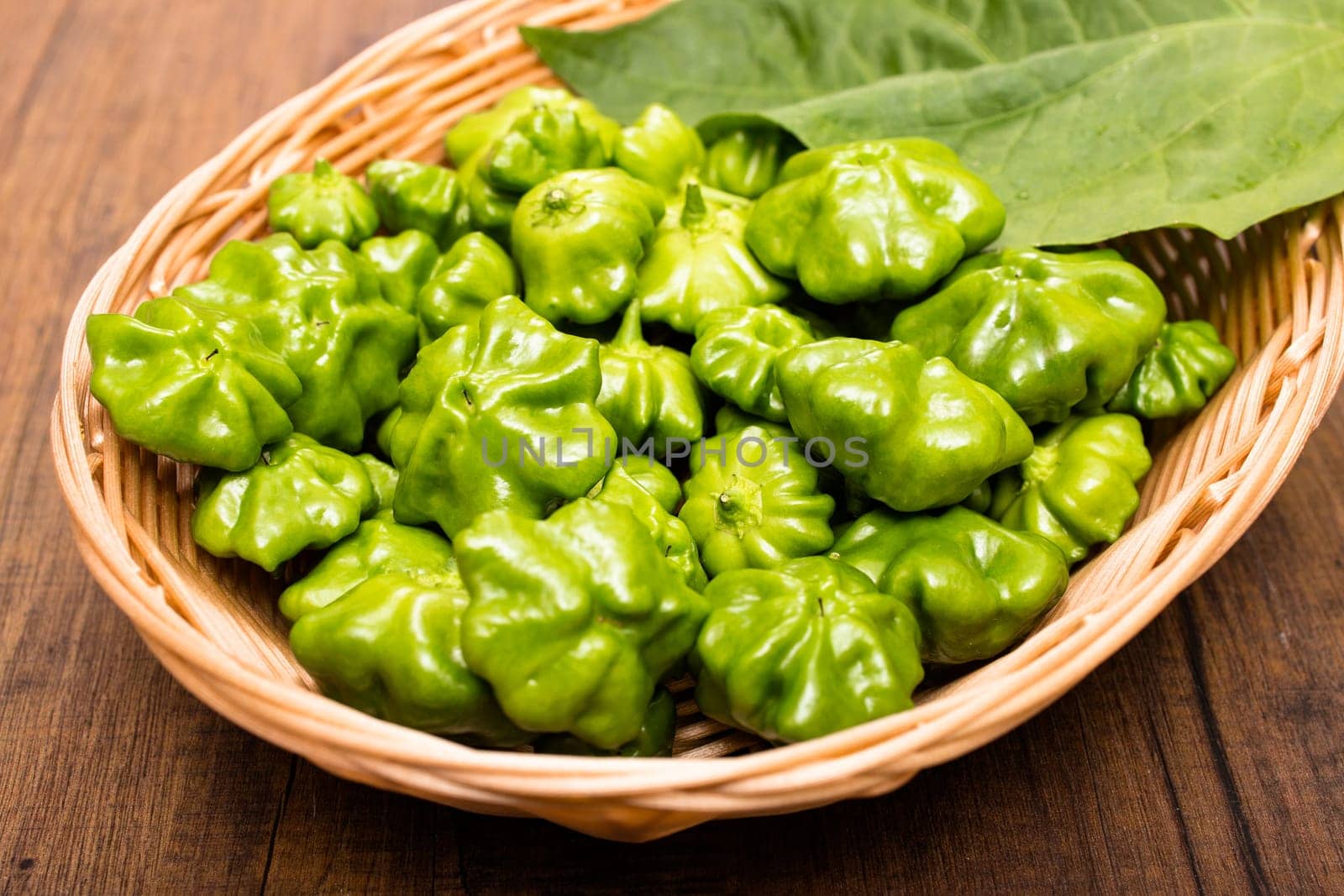 Green spicy chilli peppers in a basket