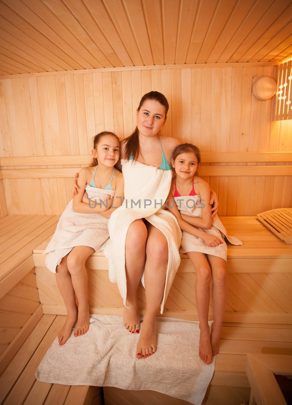 Portrait of woman with little girls relaxing at finnish sauna