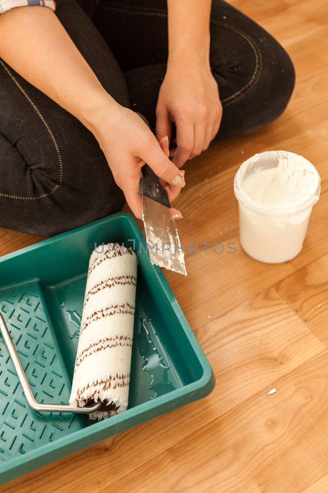 Closeup photo of woman holding painting tools and spatula