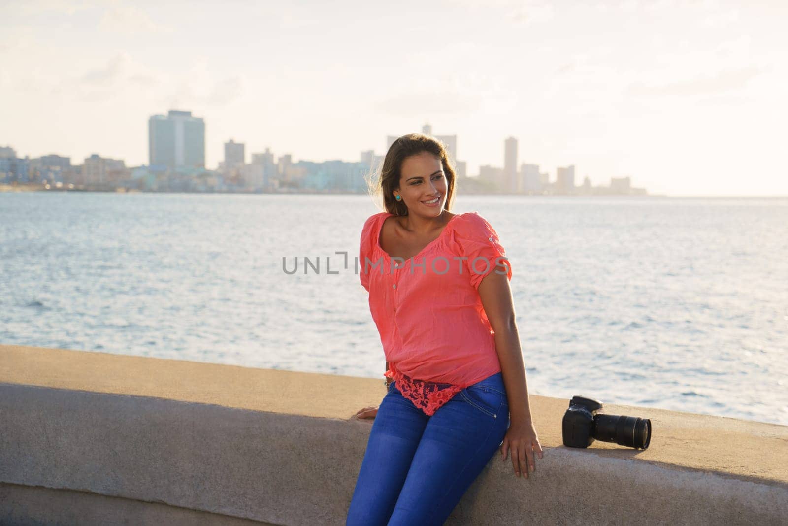 Portrait of young girl in la habana, cuba, relaxing and taking pictures near the sea
