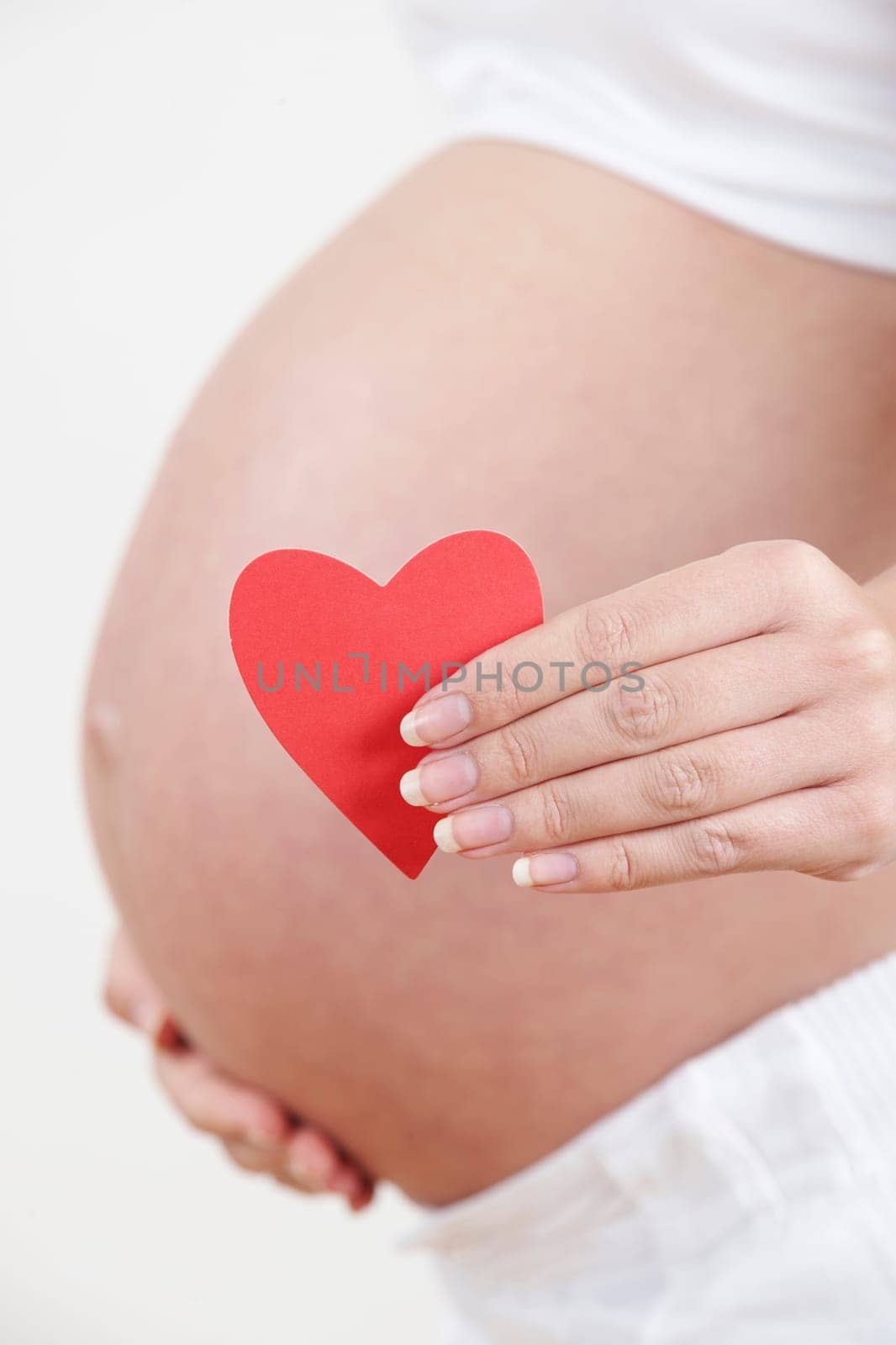 Close Up Of Pregnant Woman Holding Heart Shape