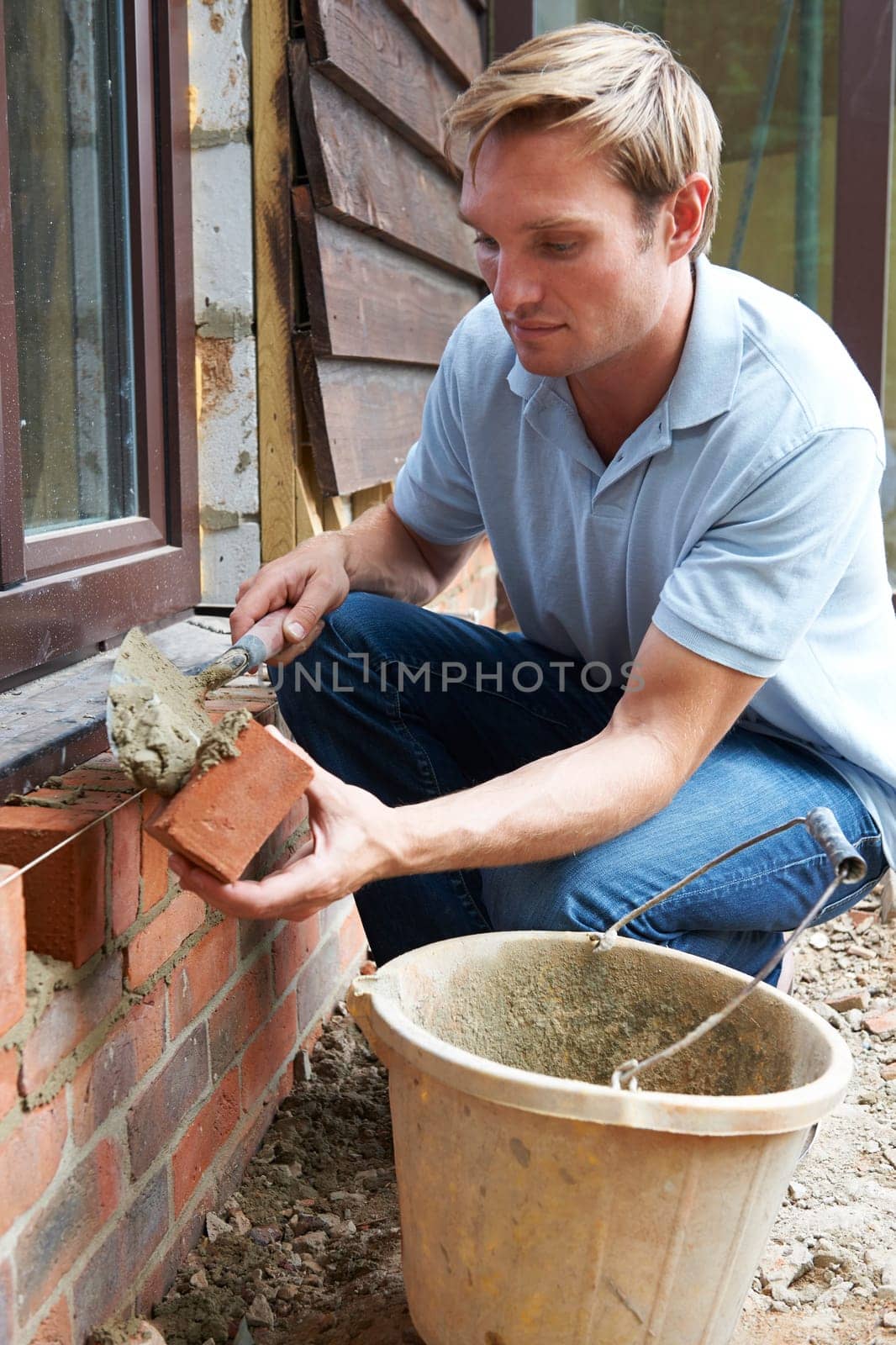 Construction Worker Laying Bricks
