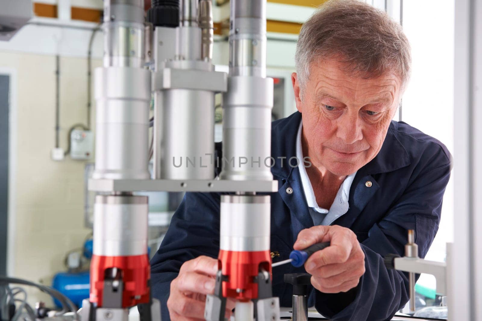 Engineer Working On Machine In Factory