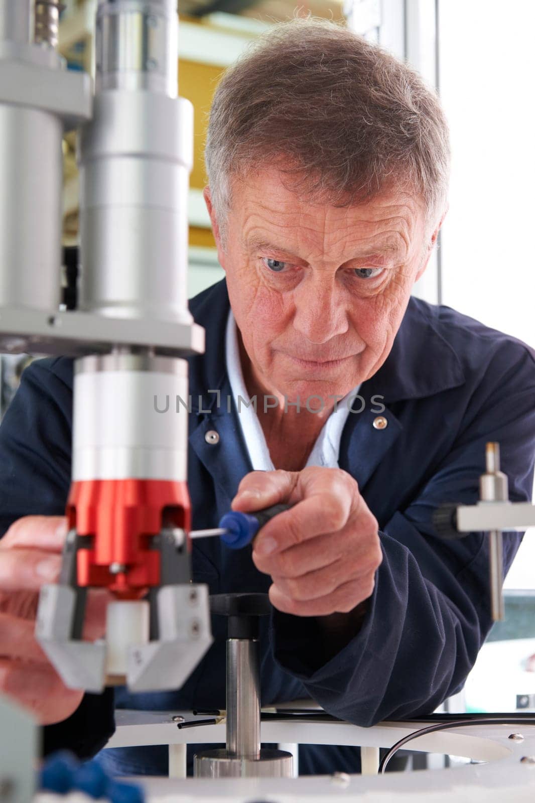 Engineer Working On Machine In Factory