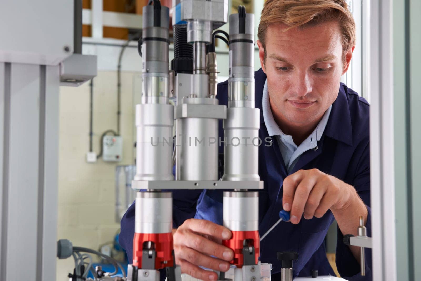 Engineer Working On Machine In Factory