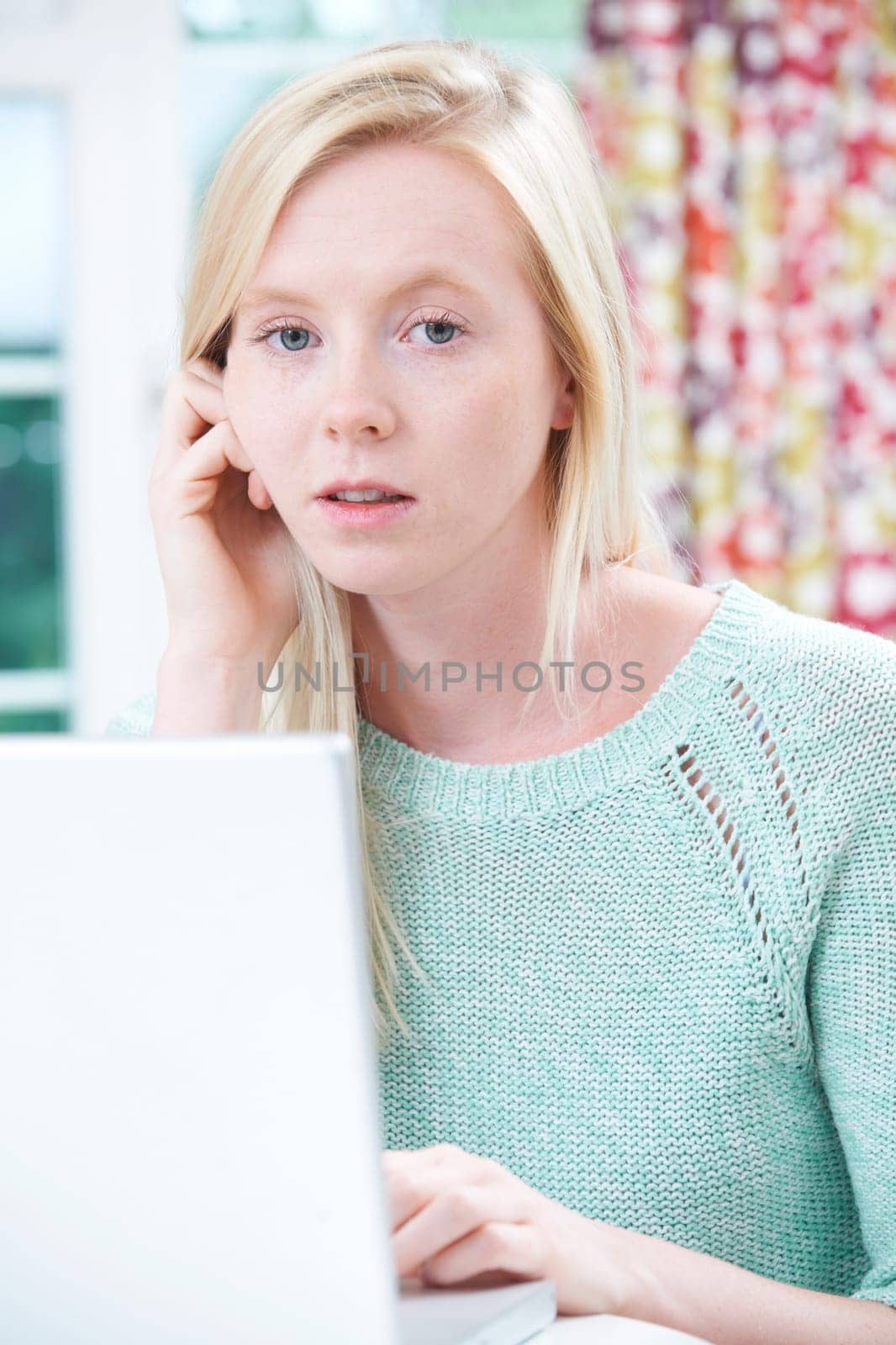 Worried Teenage Girl Using Laptop At Home