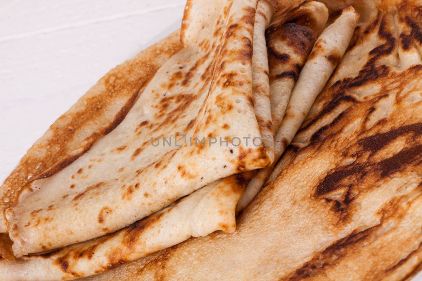 delicious fresh crepes pancakes pancakes on a white plate on a rustic white wooden board