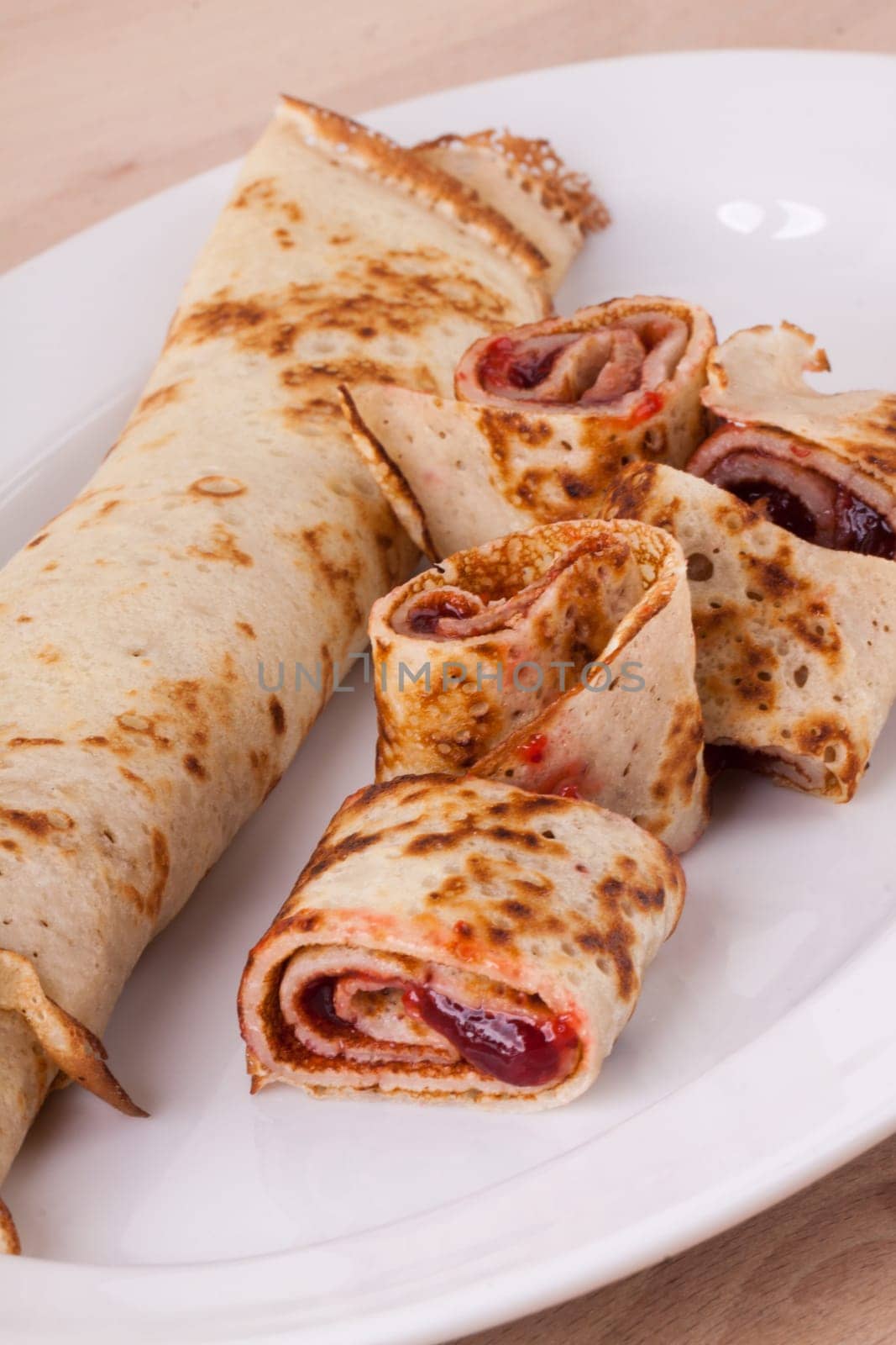 Pancake crepes tortilla filled with maraufas as dessert on a white plate