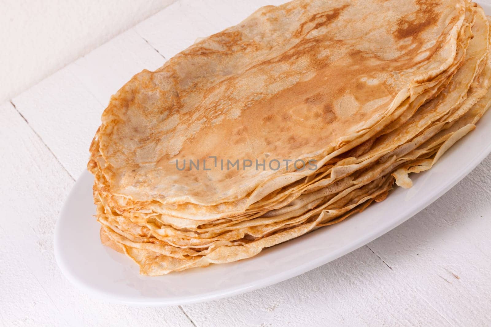 delicious fresh crepes pancakes pancakes on a white plate on a rustic white wooden board