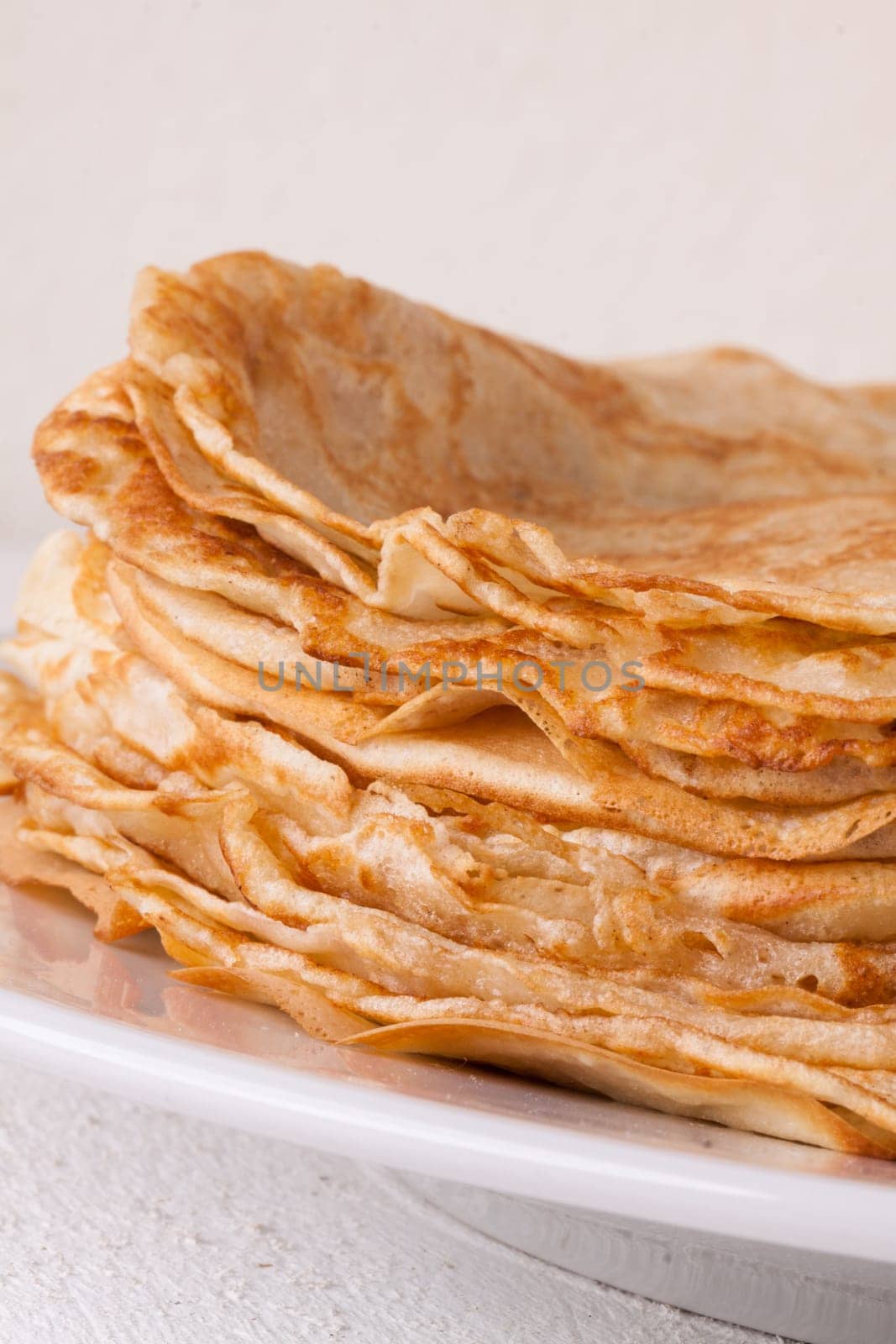 delicious fresh crepes pancakes pancakes on a white plate on a rustic white wooden board