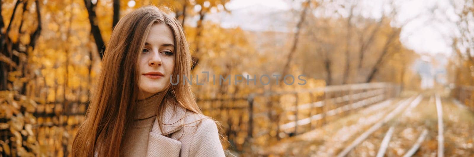 beautiful long-haired woman walks through the autumn streets. Railway, autumn, woman in a coat. by Annu1tochka