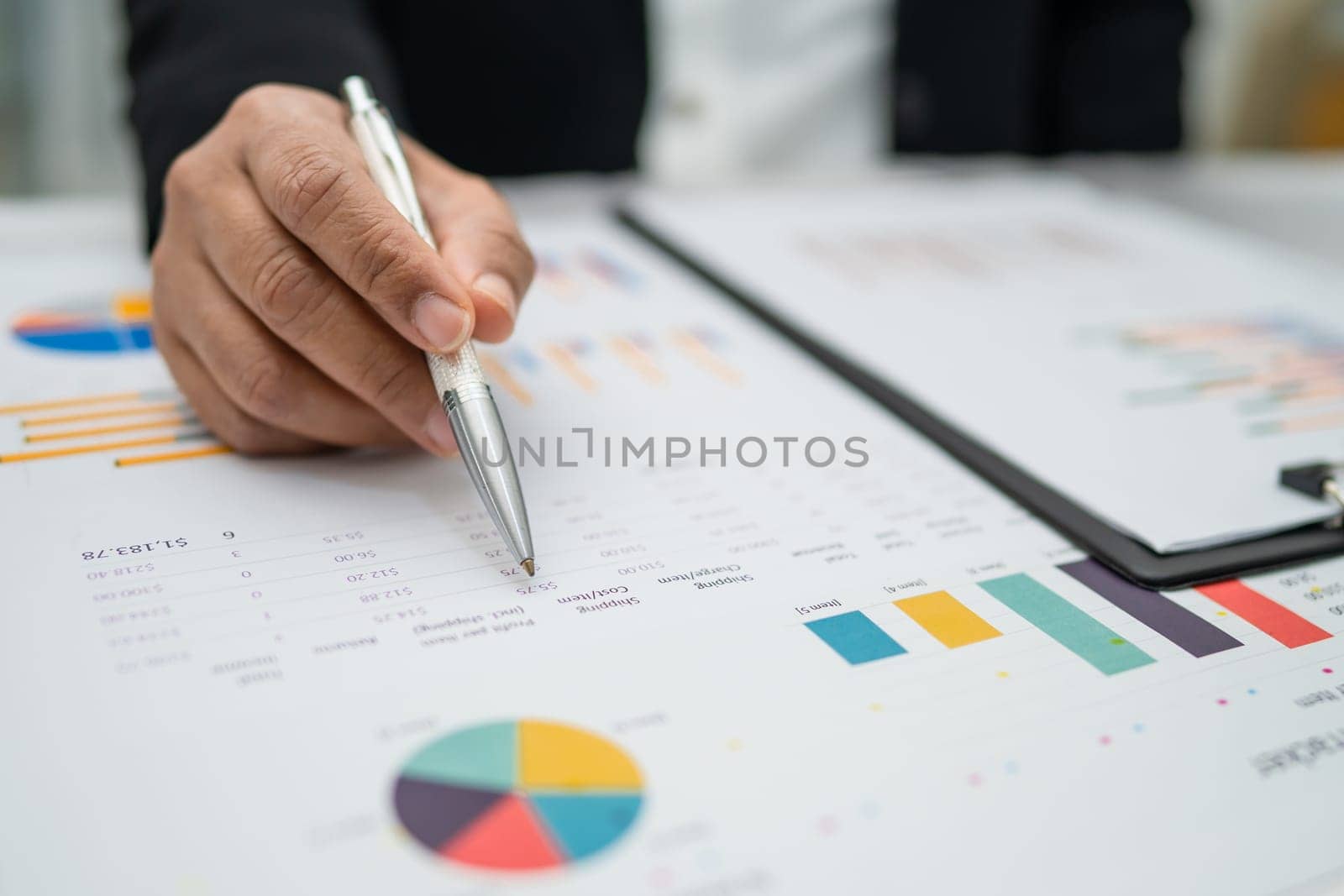 Asian accountant working and analyzing financial reports project accounting with chart graph in  office, finance and business.  by pamai