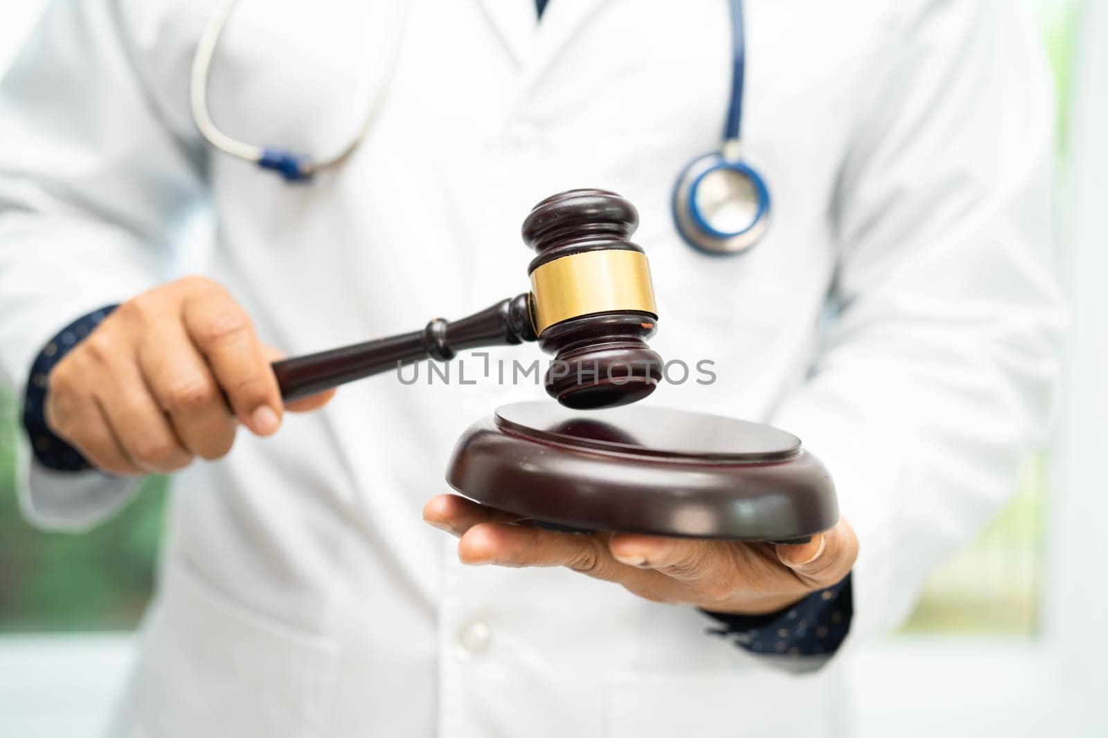 Doctor holding judge gavel, forensic medicine, medical law and crime justice concept. by pamai