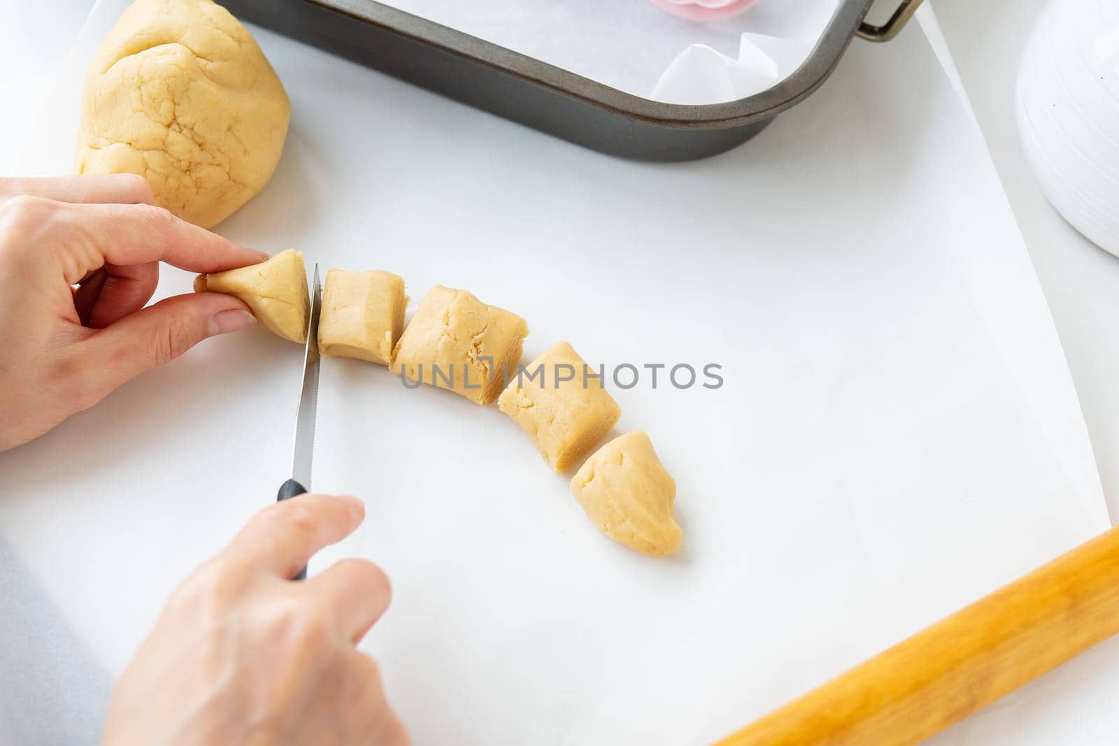 The process of making cookies with shapes in the form of flowers, a rolling pin and a tray, the concept of cooking, baking at home