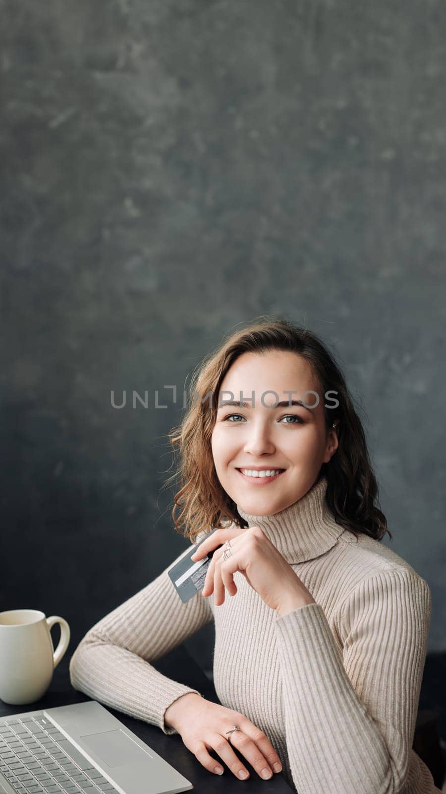 Seamless E-commerce Experience. Young Woman Shopping Online with Credit Card and Laptop. Young woman holding credit card and using laptop computer. Online shopping concept.