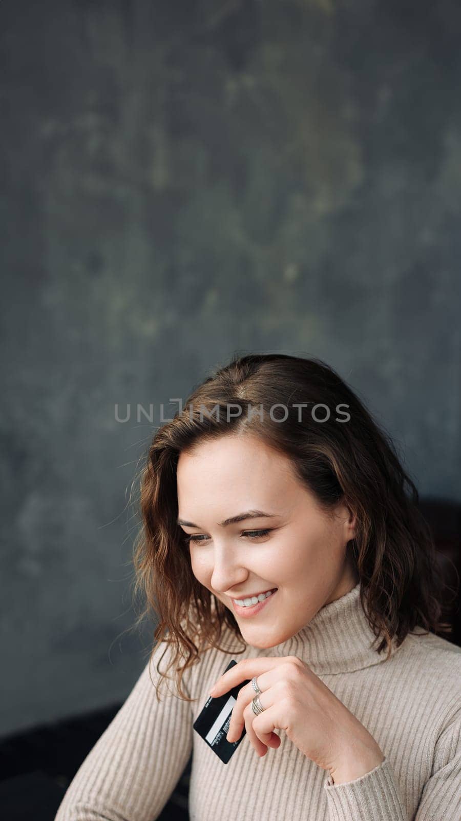 Convenient Online Shopping. Young Woman with Credit Card and Laptop Engages in E-commerce. Young woman holding credit card and using laptop computer. Online shopping concept.