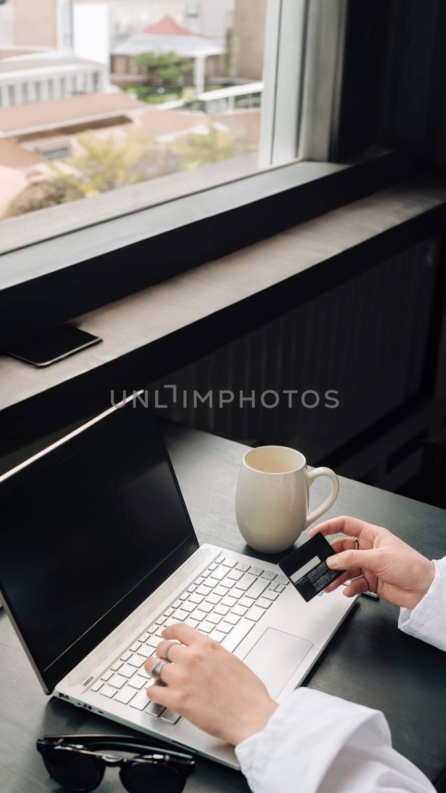 Effortless Online Shopping: Woman's Hands with Credit Card and Laptop. Digital Retail Elegance: Woman Shopping Online with Laptop and Credit Card. Convenient Online Purchase.