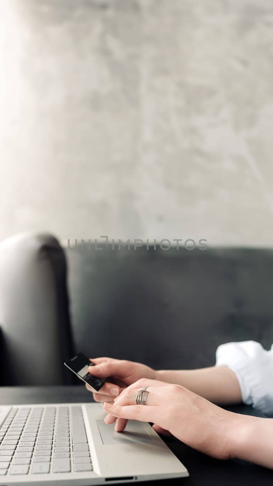 Elegant Online Shopping. Woman's Hands Gracefully Hold Credit Card, Making Purchases with Laptop - E-commerce Concept.