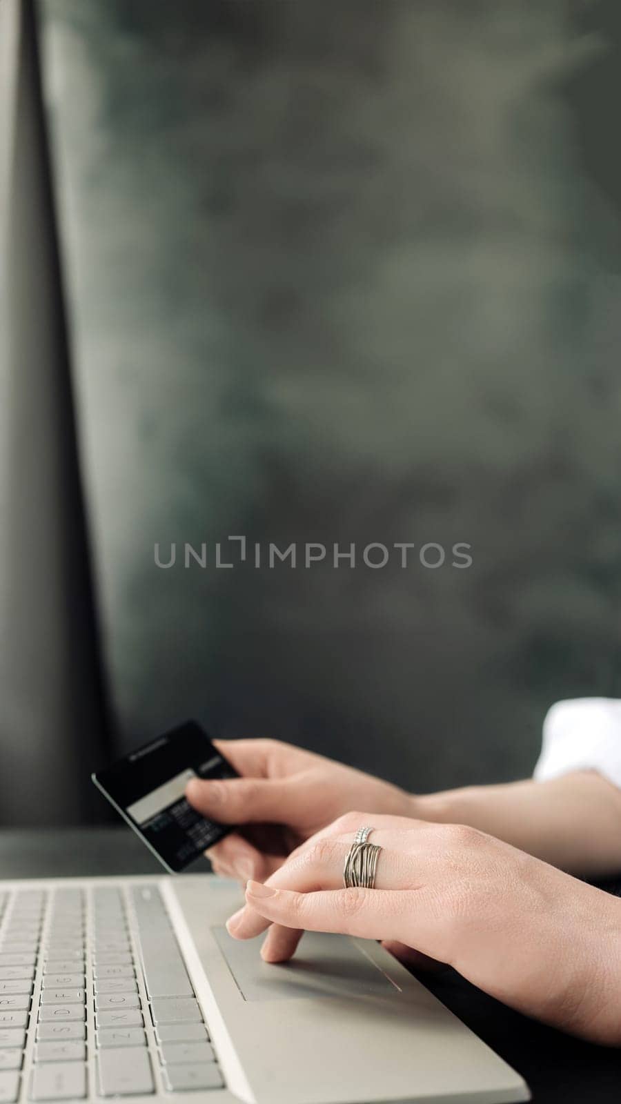 Graceful Online Shopping: Woman's Hands Hold Credit Card, Engaging in E-commerce with Laptop - Conceptual Image. Convenience of Online Shopping: Woman's Hands, Credit Card, and Laptop.