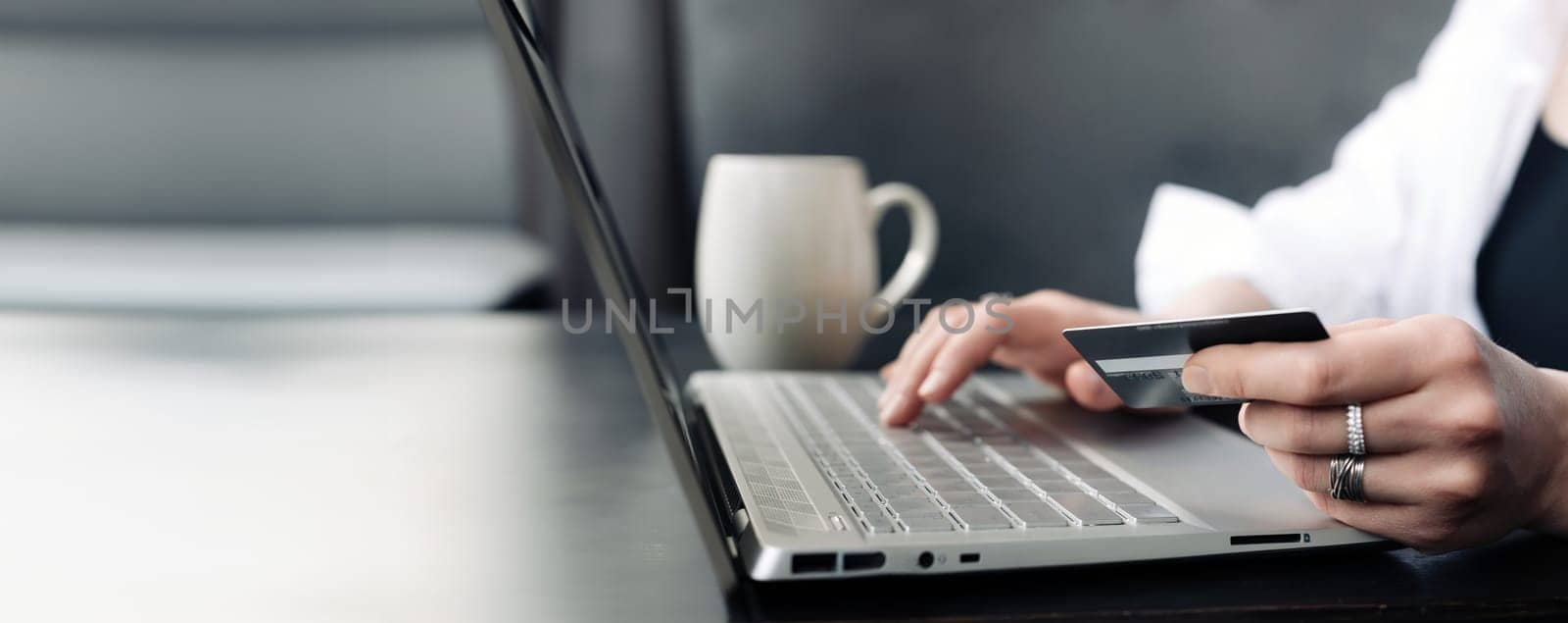 Modern Shopping Experience. Woman's Hand with Credit Card and Laptop. Online Purchases Made Easy: Woman's Hand on Credit Card and Laptop. Tech-Savvy Shopper. Woman's Hand Engaged in Online Shopping.