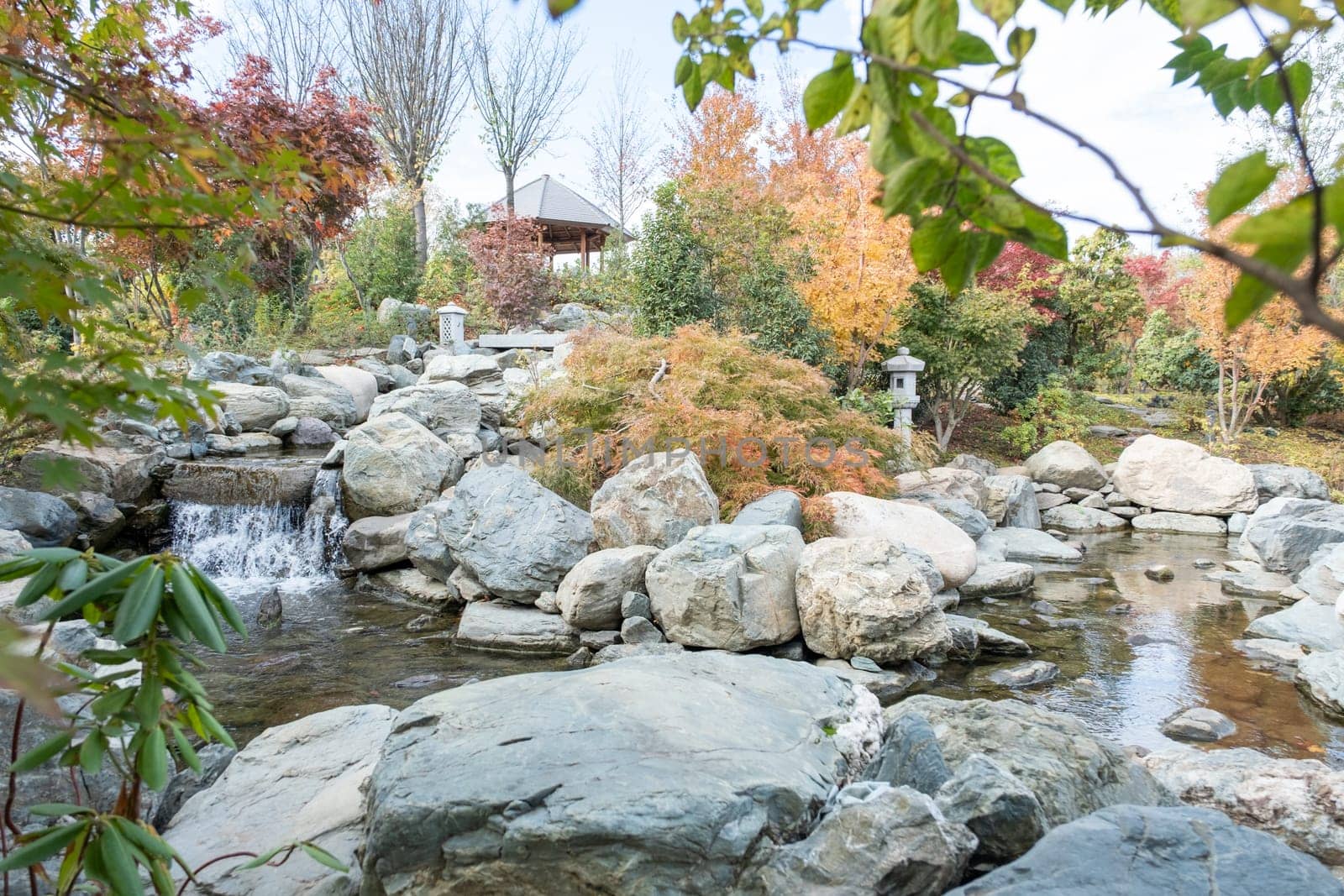 Woman in red plaid shirt enjoying nature sitting in Japanese Garden