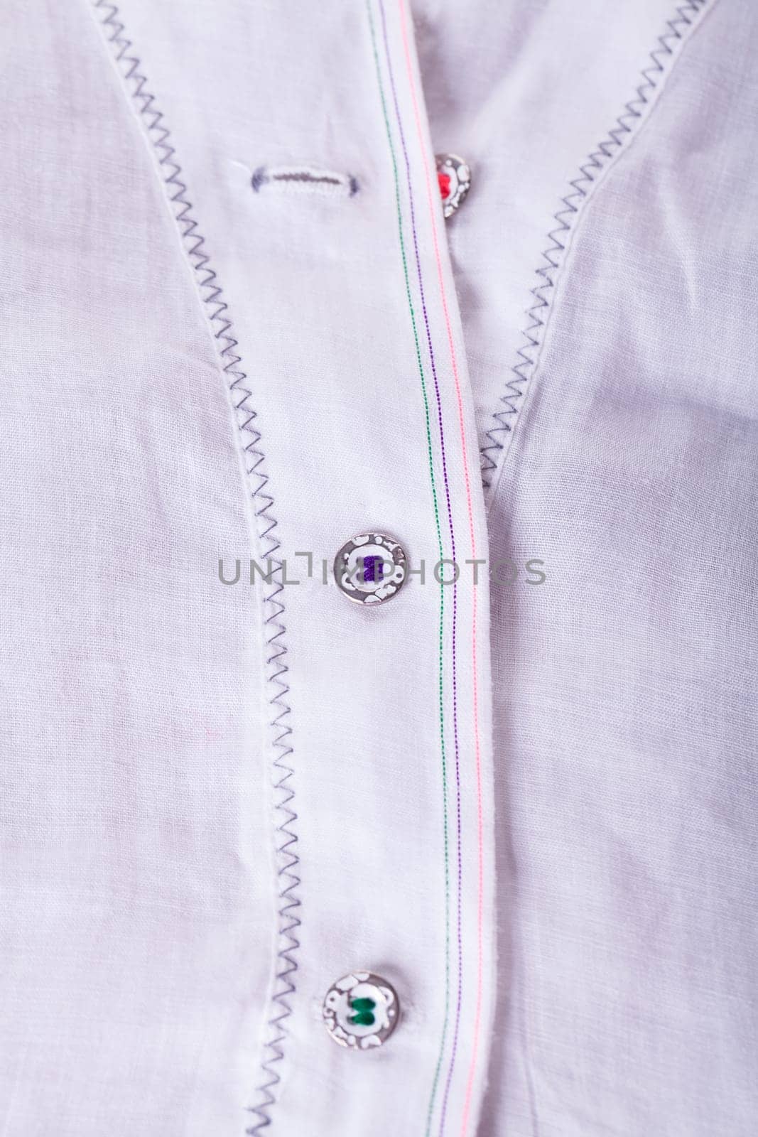 Button strip with button and buttonhole of a blouse as close-up structure texture