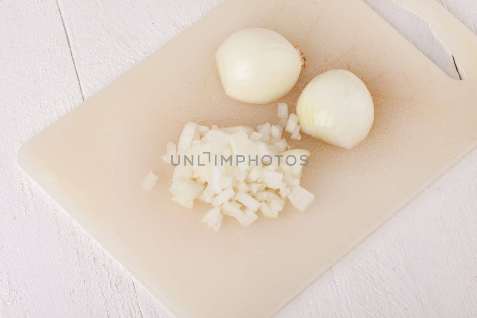 White and red onions peeled and with slurs as a whole and in cubebrunoise as a close-up on cutting board