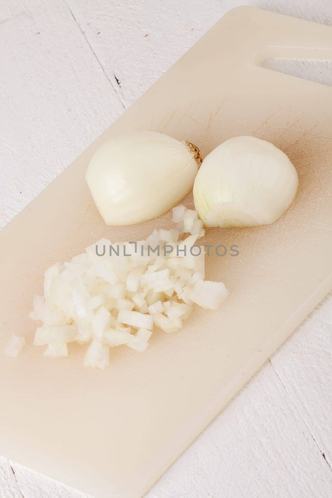 White and red onions peeled and with slurs as a whole and in cubebrunoise as a close-up on cutting board