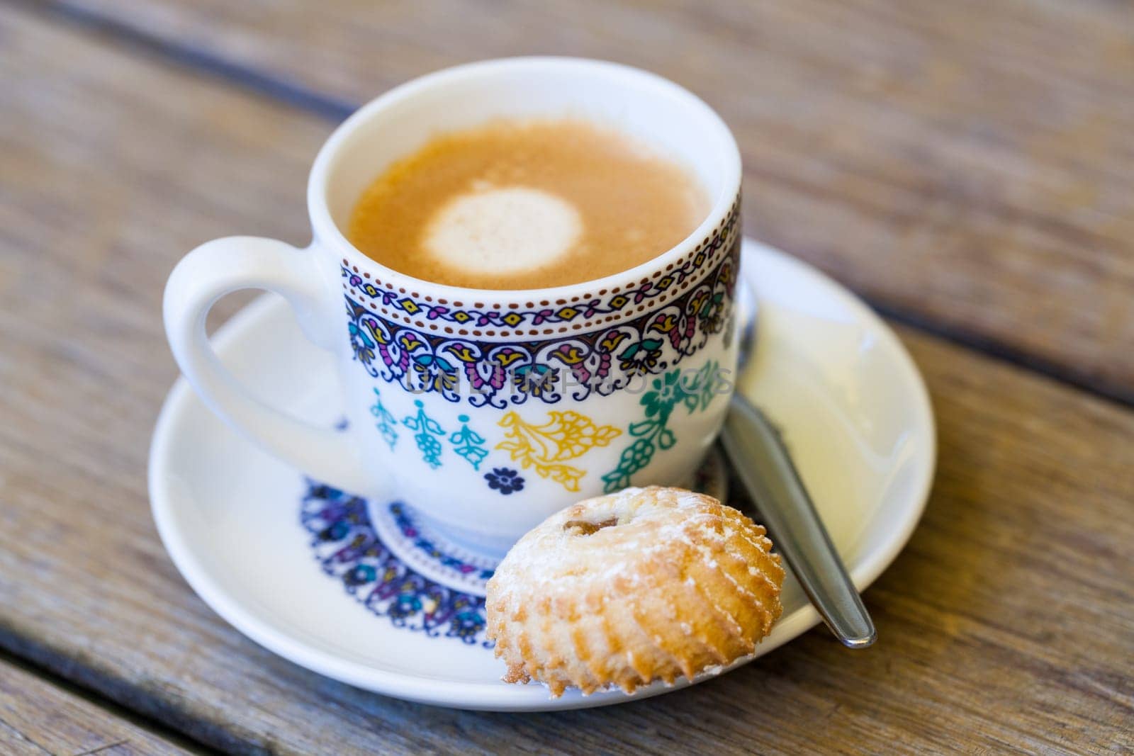Cup with fresh coffee espresso coffee spoon and pastries as close-up