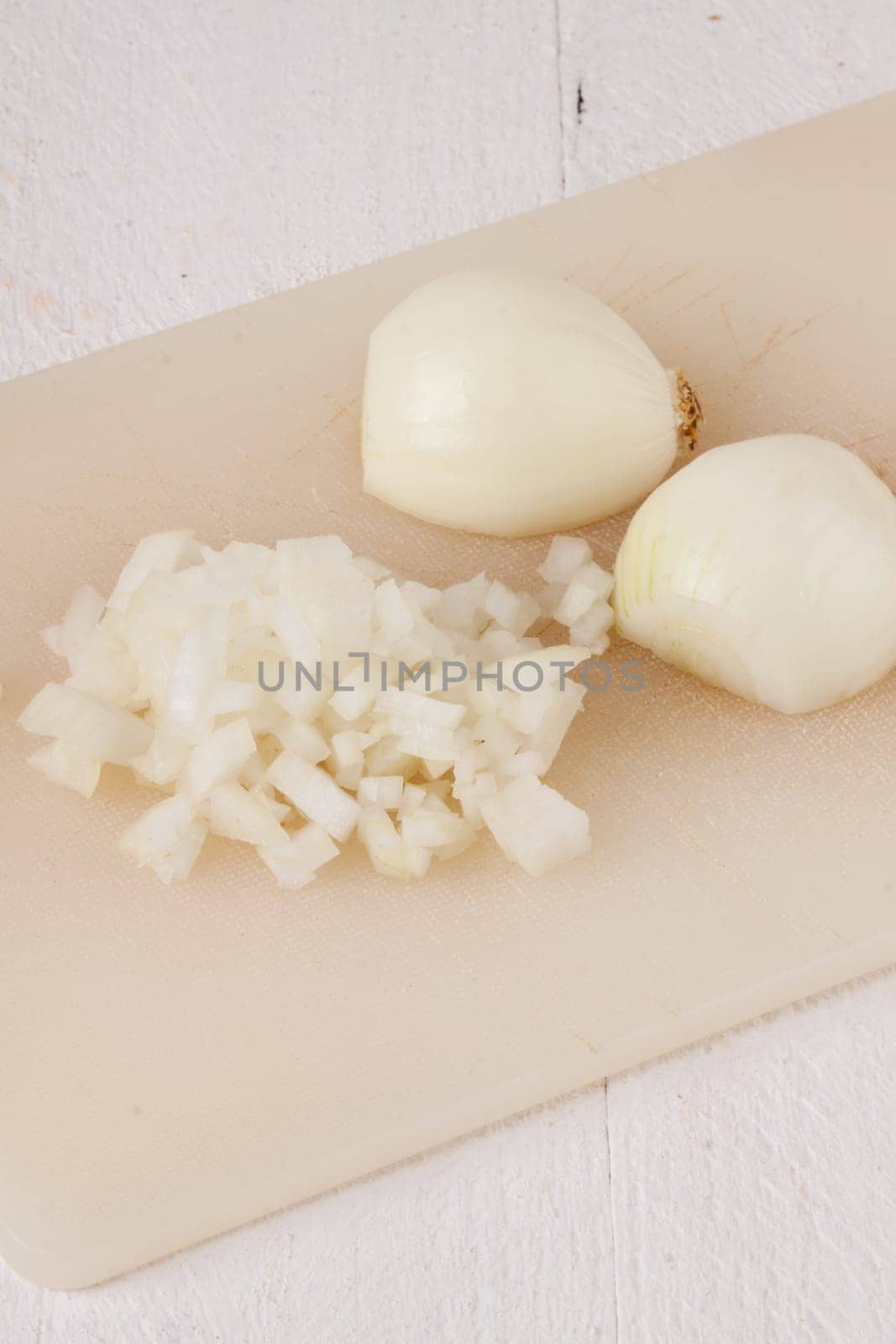 White and red onions peeled and with slurs as a whole and in cubebrunoise as a close-up on cutting board