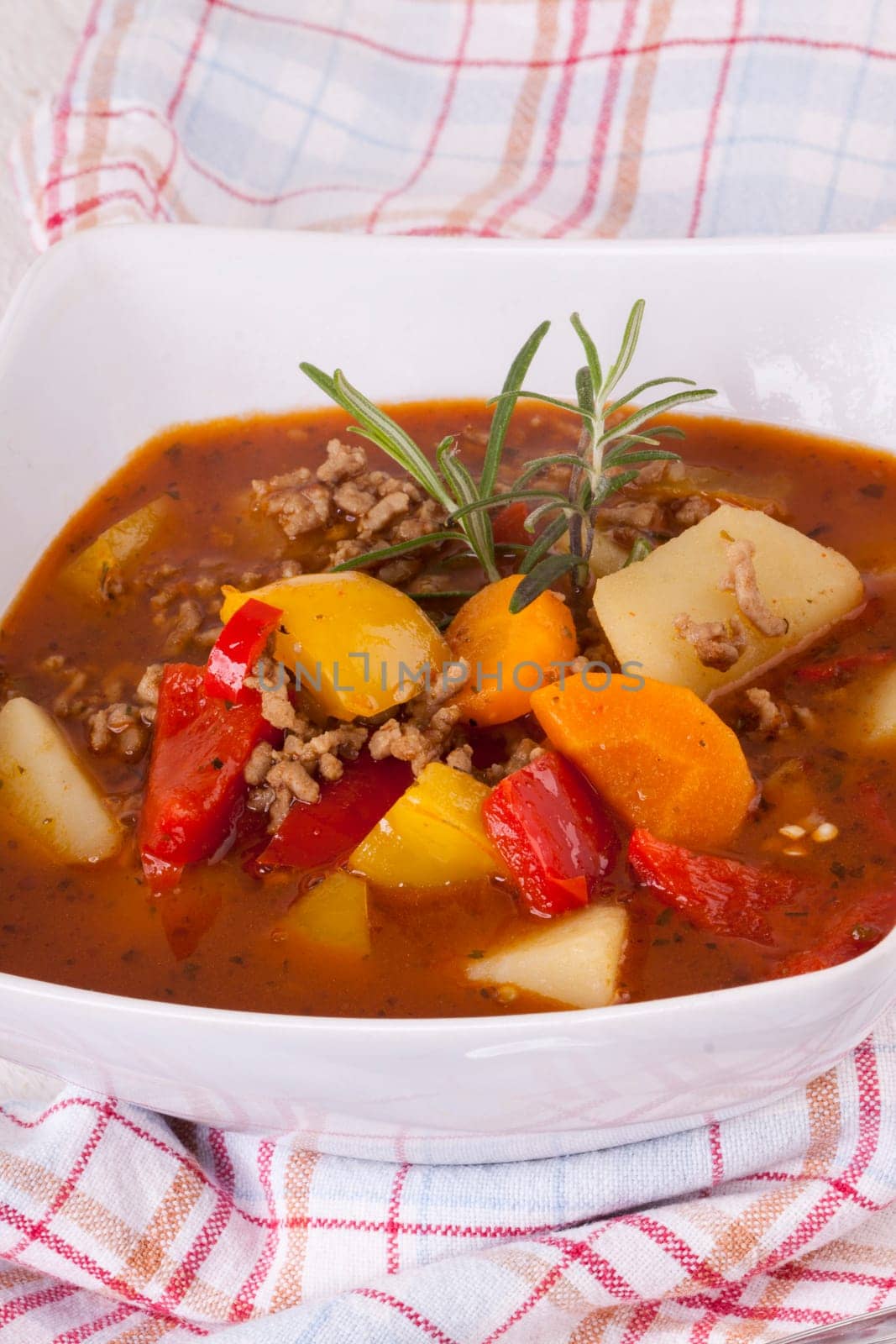 Bowl with stew goulash soup with potatoes and peppers as close-up