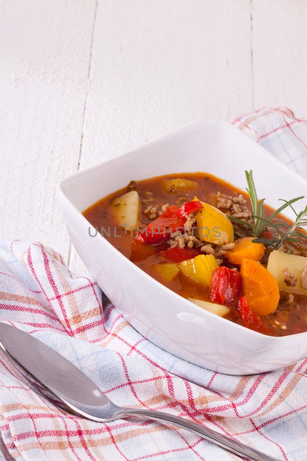 Bowl with stew goulash soup with potatoes and peppers as close-up