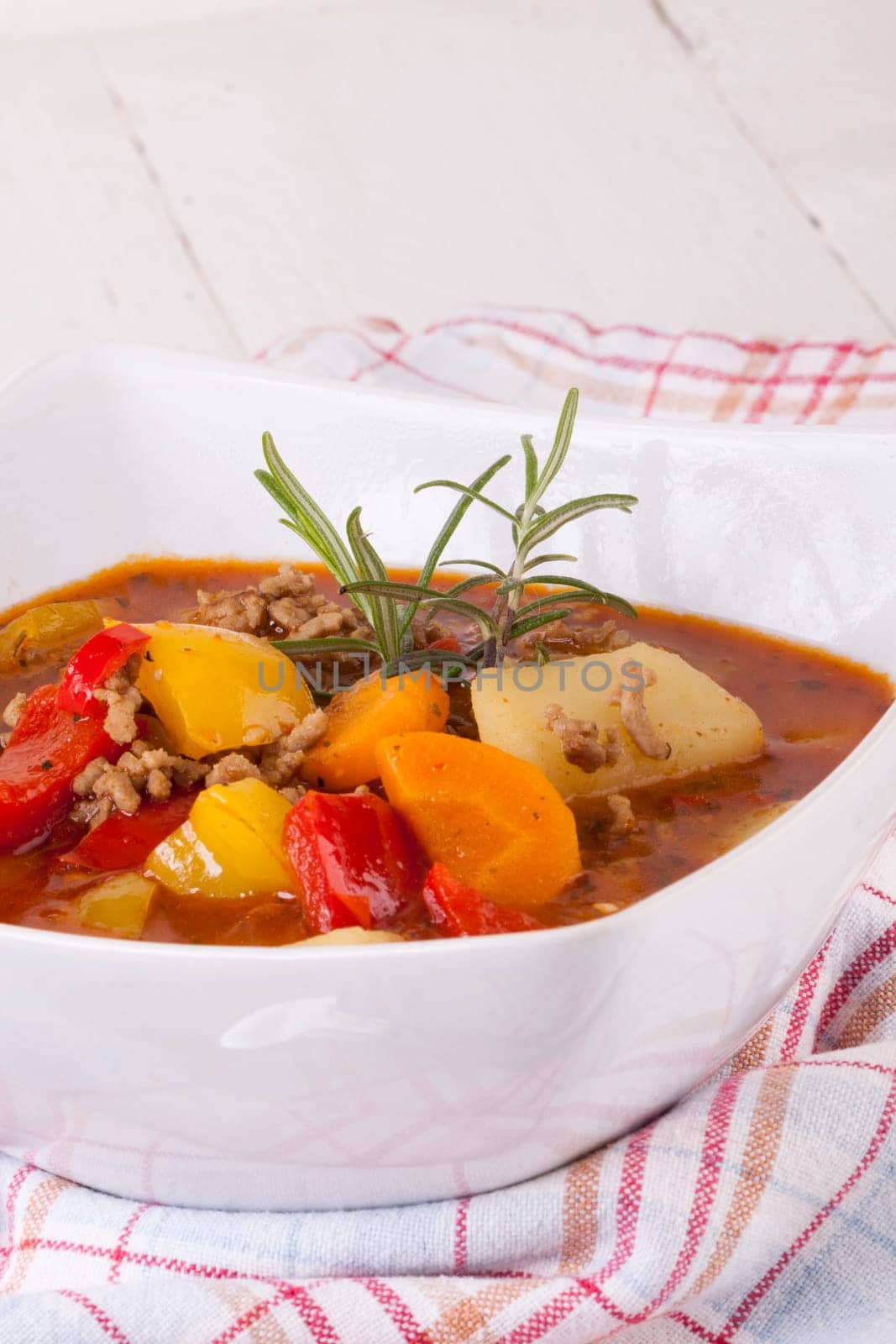 Bowl with stew goulash soup with potatoes and peppers as close-up