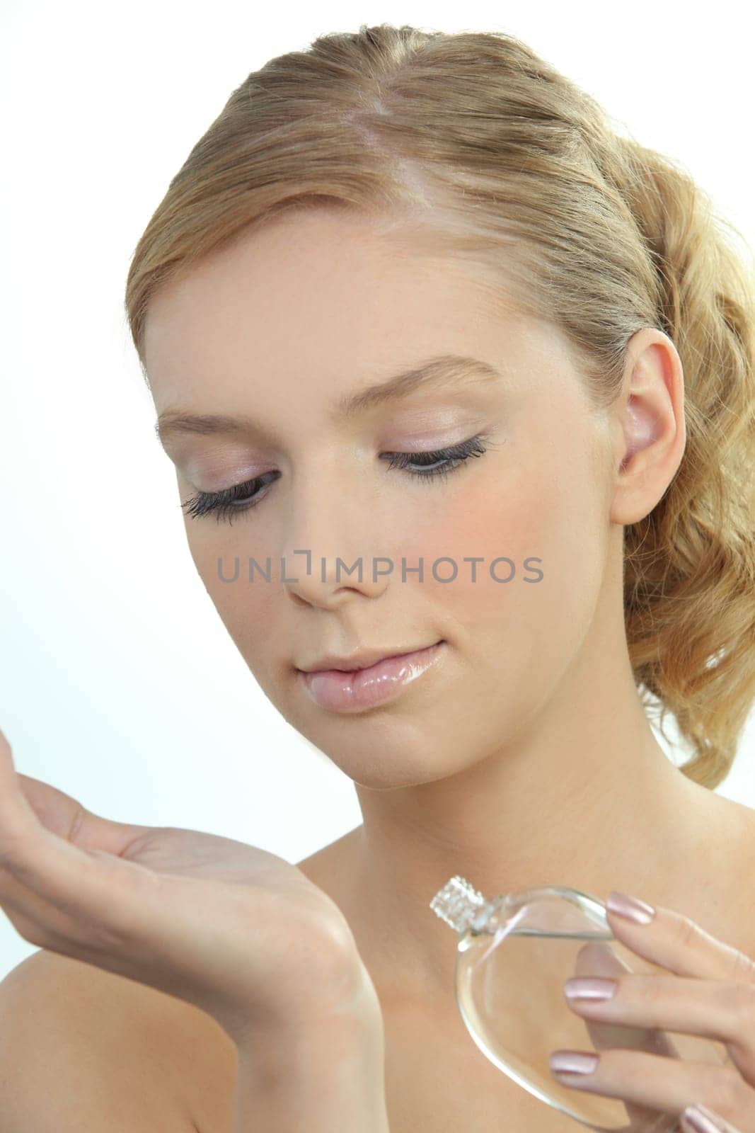 Young woman dabbing perfume onto her wrist