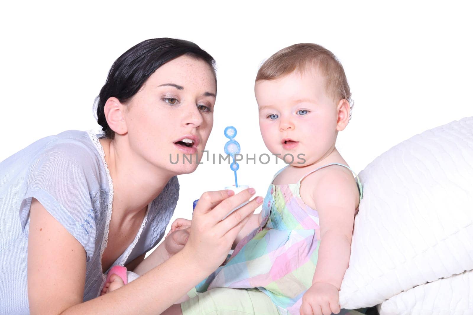 a baby and her mother looking a soap bubble solution