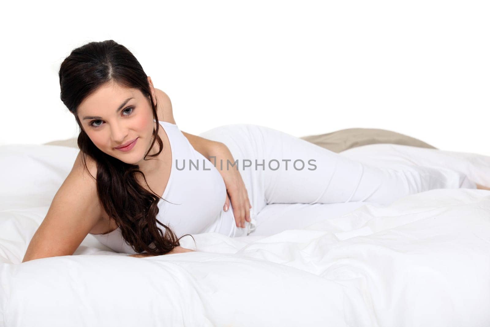 Cute brown-haired woman lying on a bed