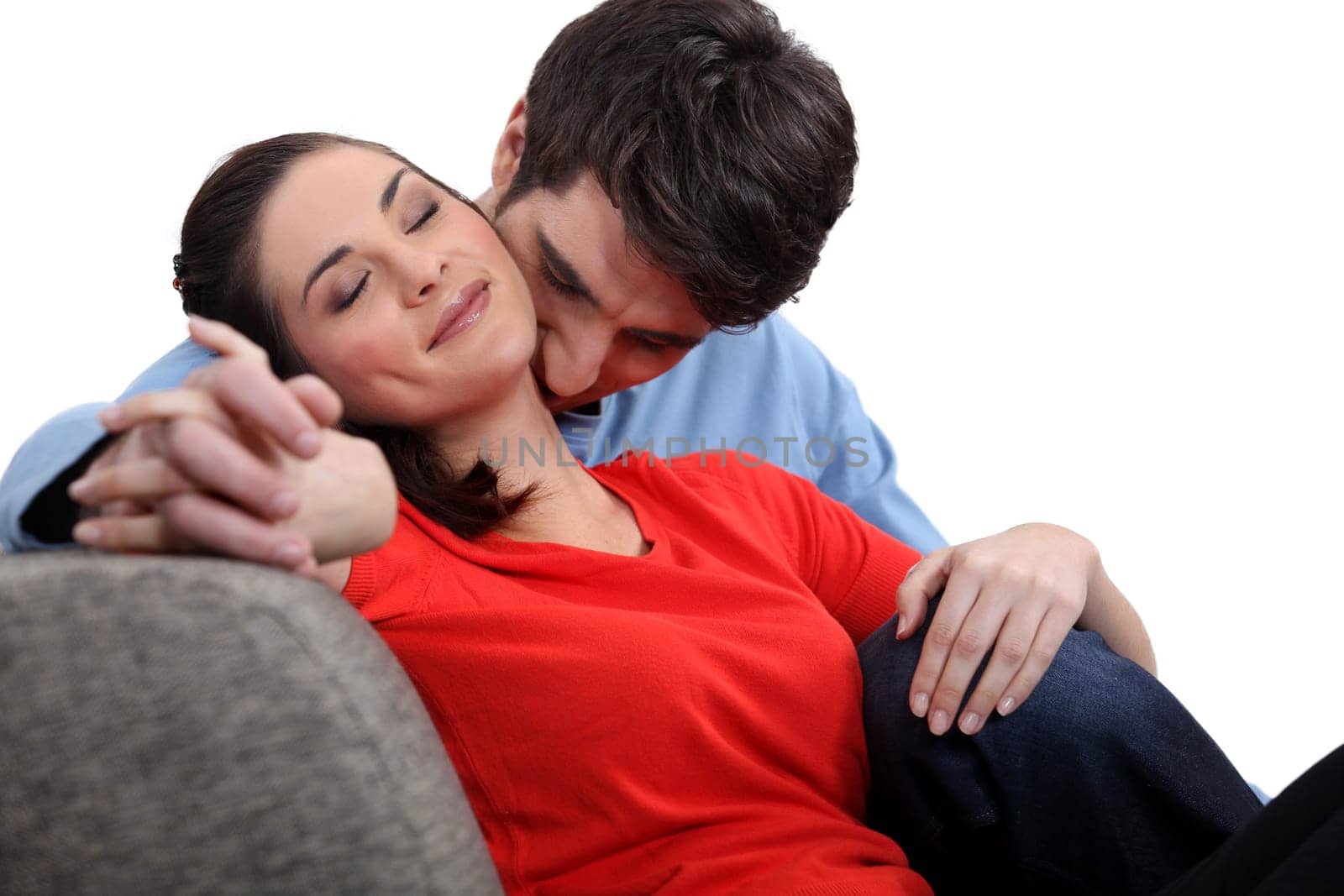 Man and woman tenderly hugging on a sofa