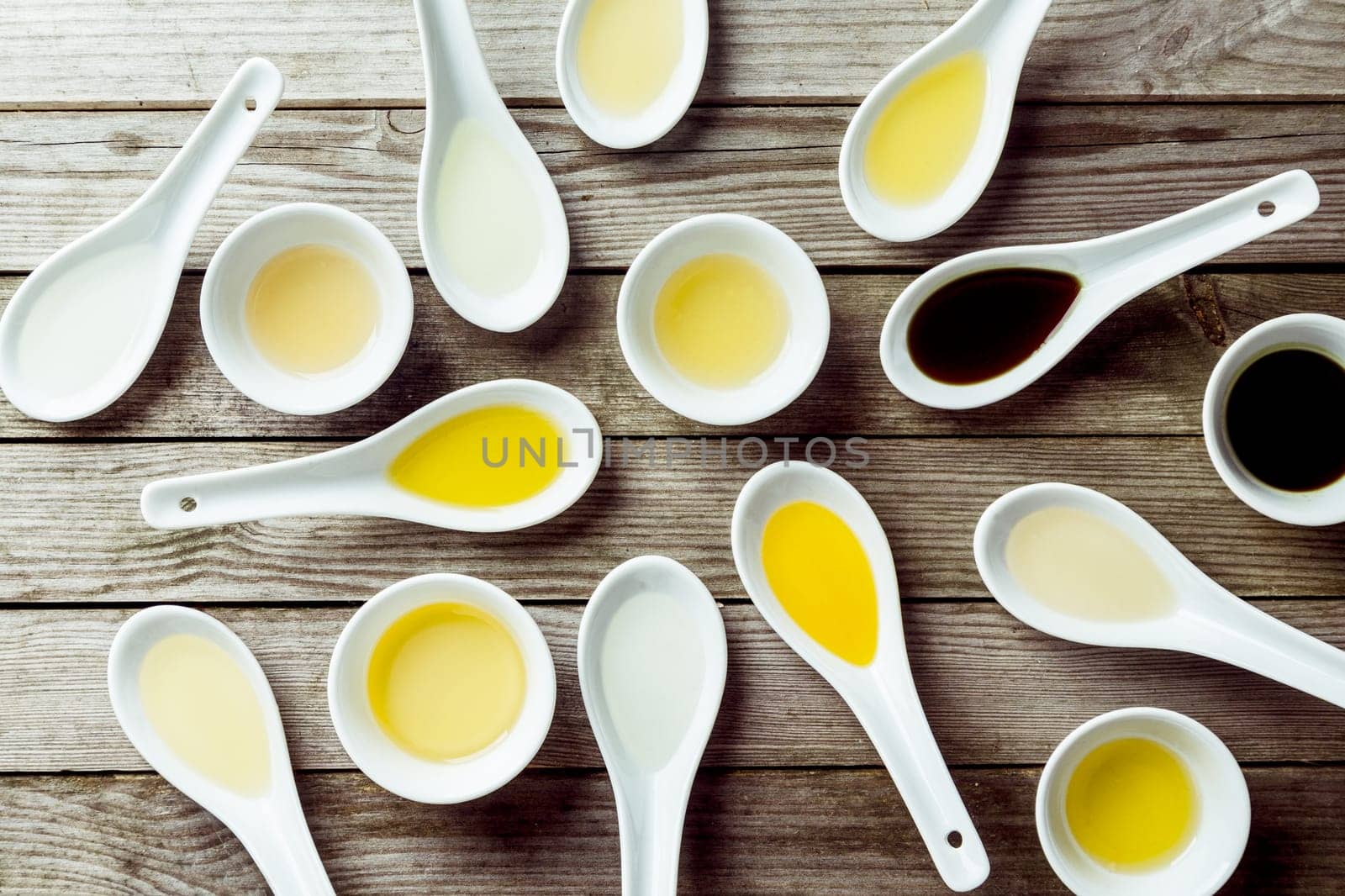 Several soup spoons and sauce dishes arranged randomly on wooden surface
