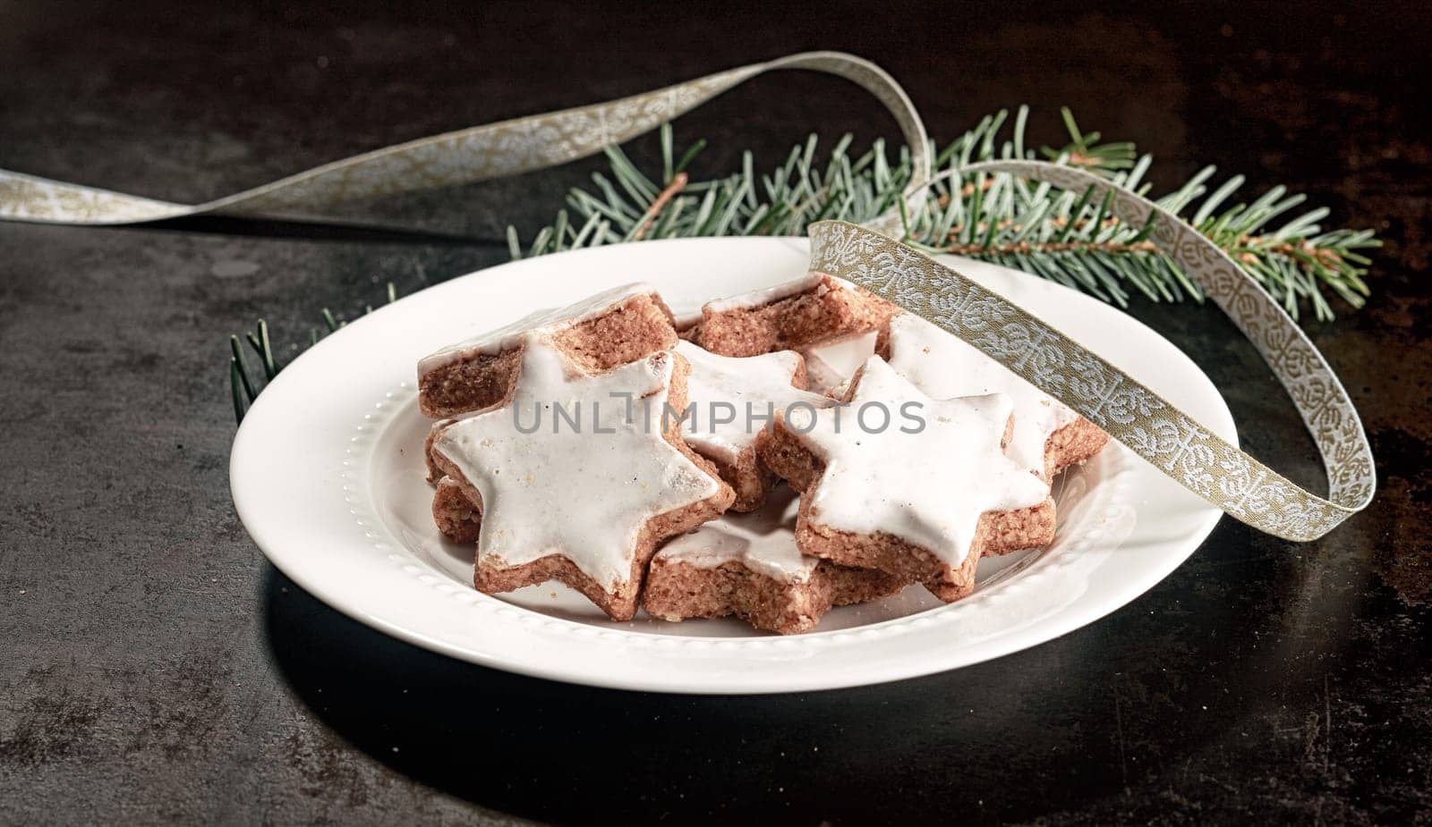 Plate of delicious crunchy Christmas star biscuits glazed with white icing for a festive seasonal snack