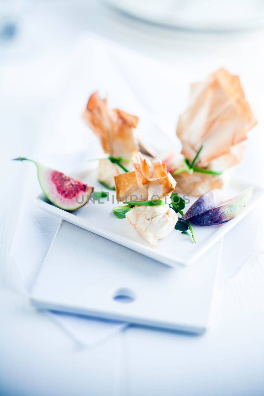Serve with Art Tasty Dessert in Flaky Pastry Bonbons on Table, Isolated White.