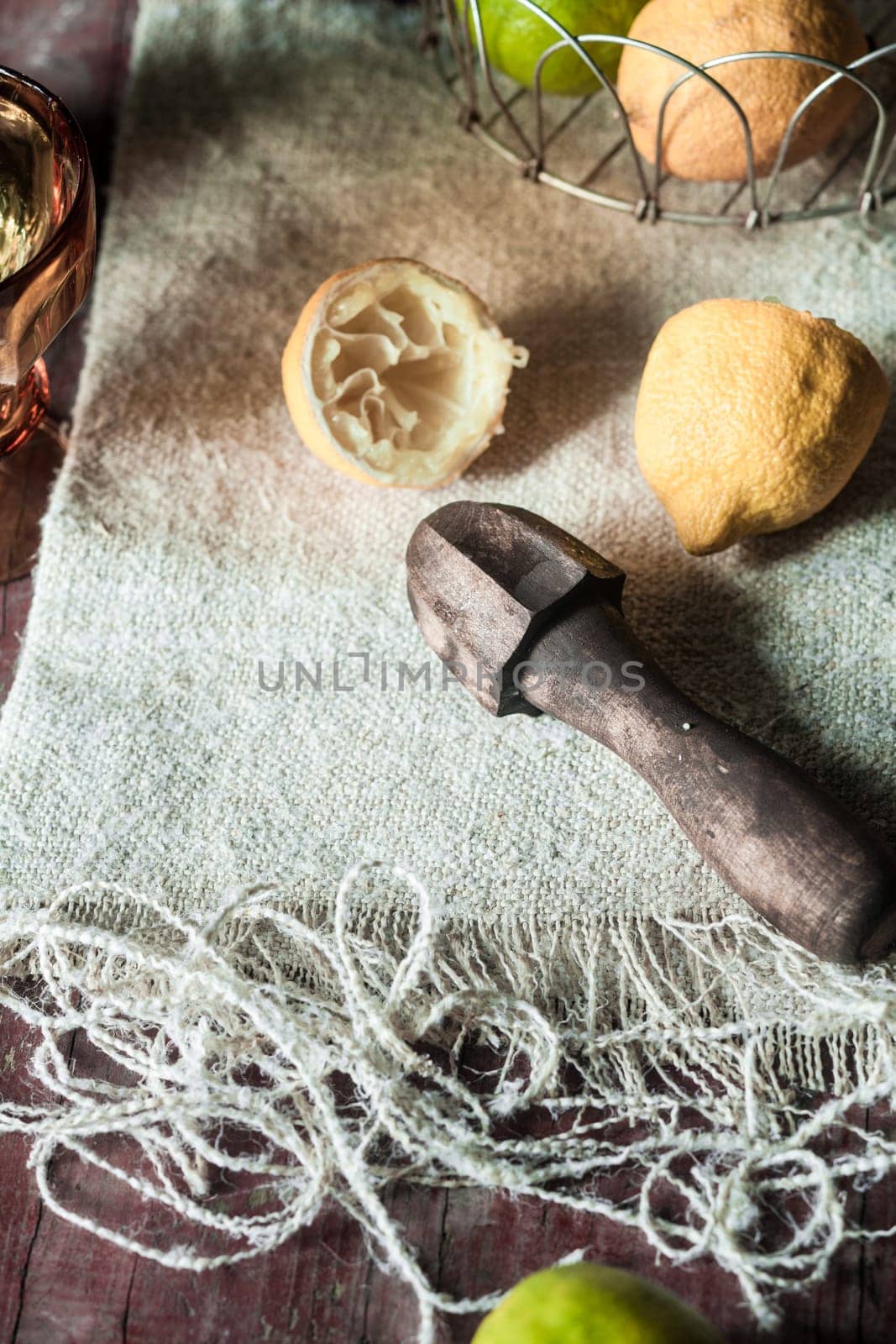 Juicing lemons with a vintage wooden reamer in a rustic kitchen