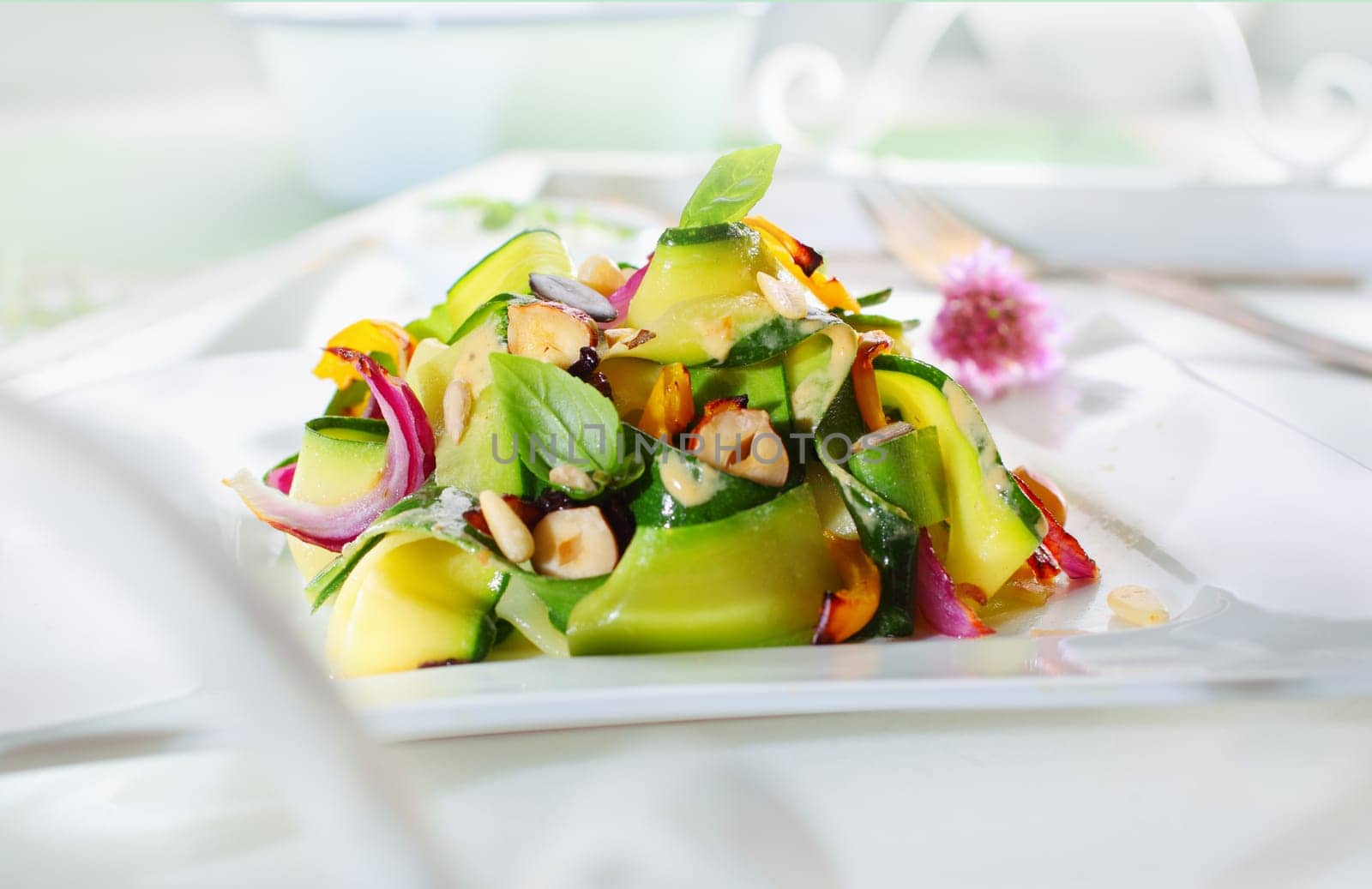 Gourmet Appetizing Fresh Green Salad with Plenty Elements, on White Table