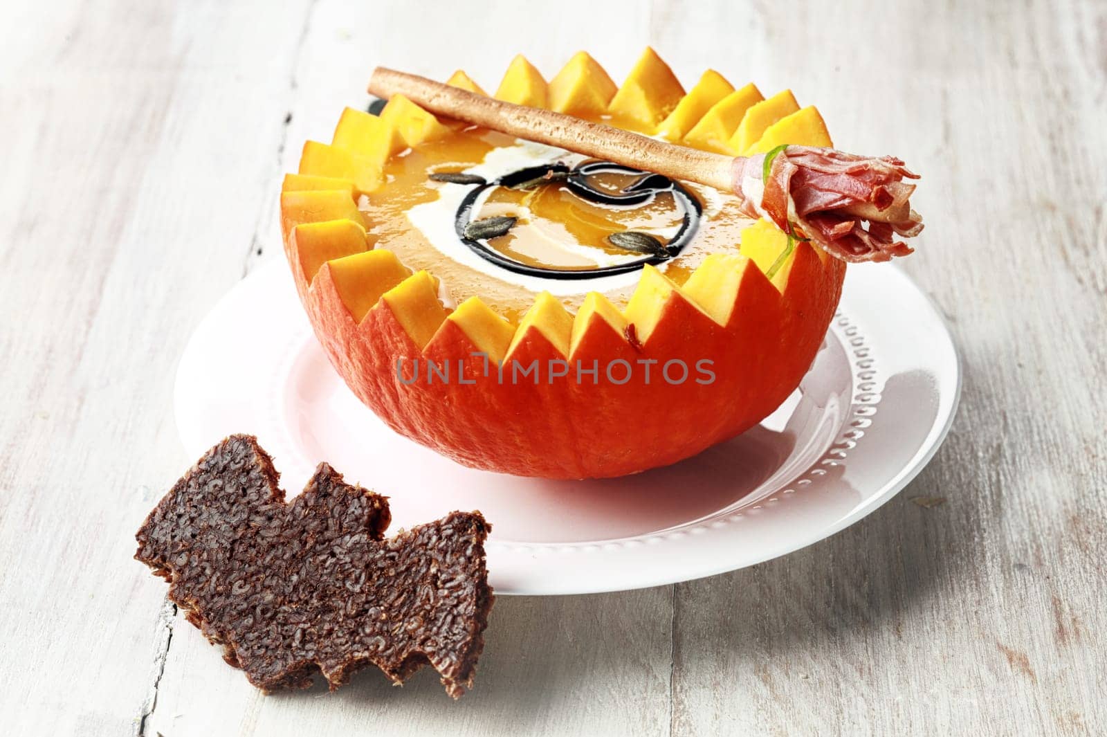 Pumpkin Soup with Bat Crouton Toast Served in Half a Pumpkin with Broomstick Breadstick