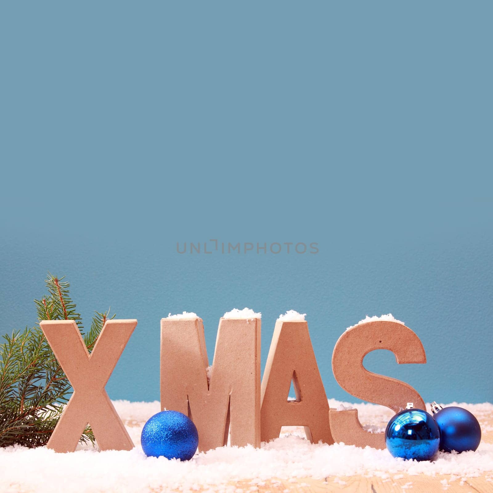 Cool blue Xmas background with snow and colorful Christmas baubles in a wintry seasonal theme with copyspace for your greeting, square format
