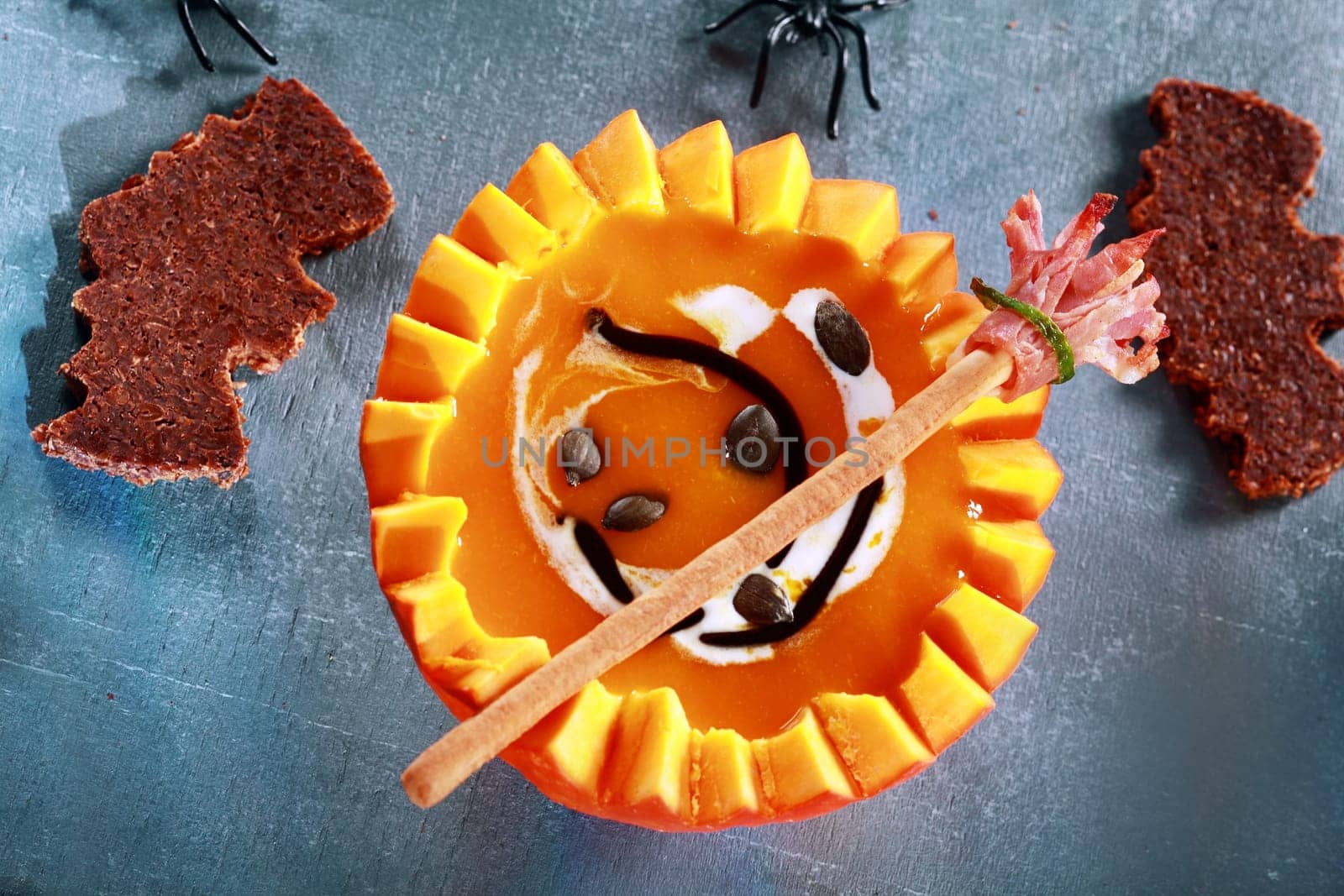 Halloween Pumpkin Soup Served in Half a Pumpkin with Bat Shaped Crouton Toasts and Broomstick Bread Stick from Above