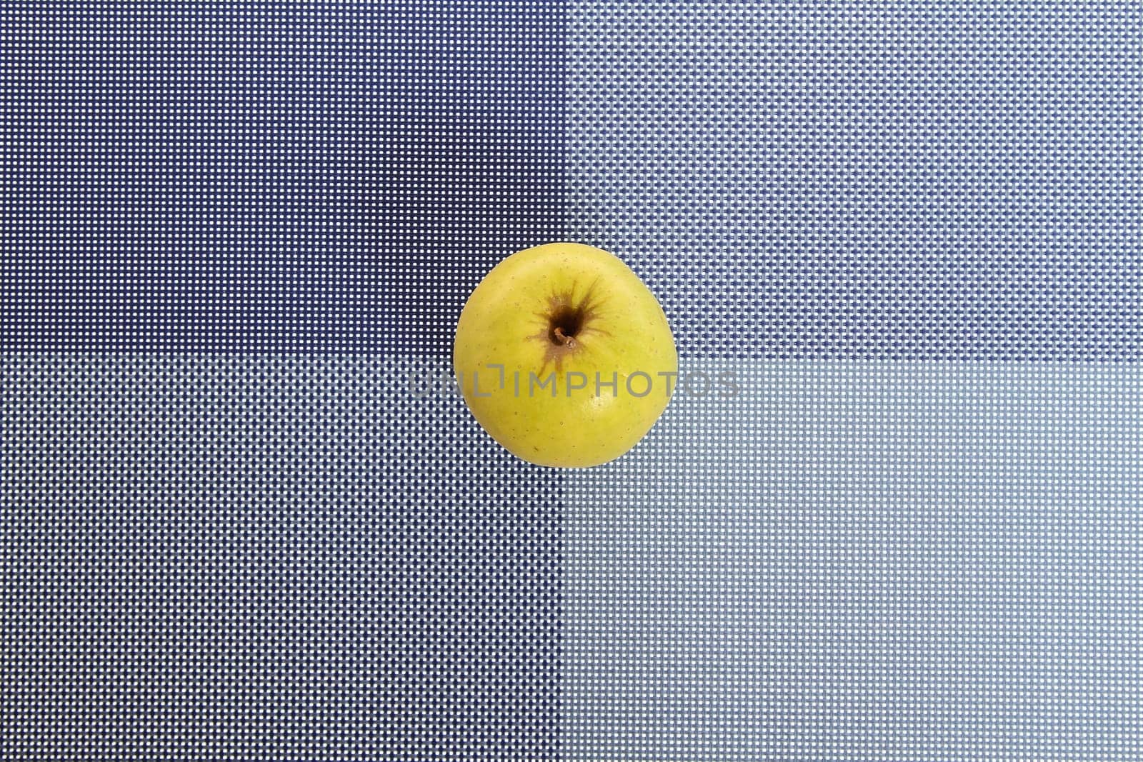 Green apple on a placemat, background.