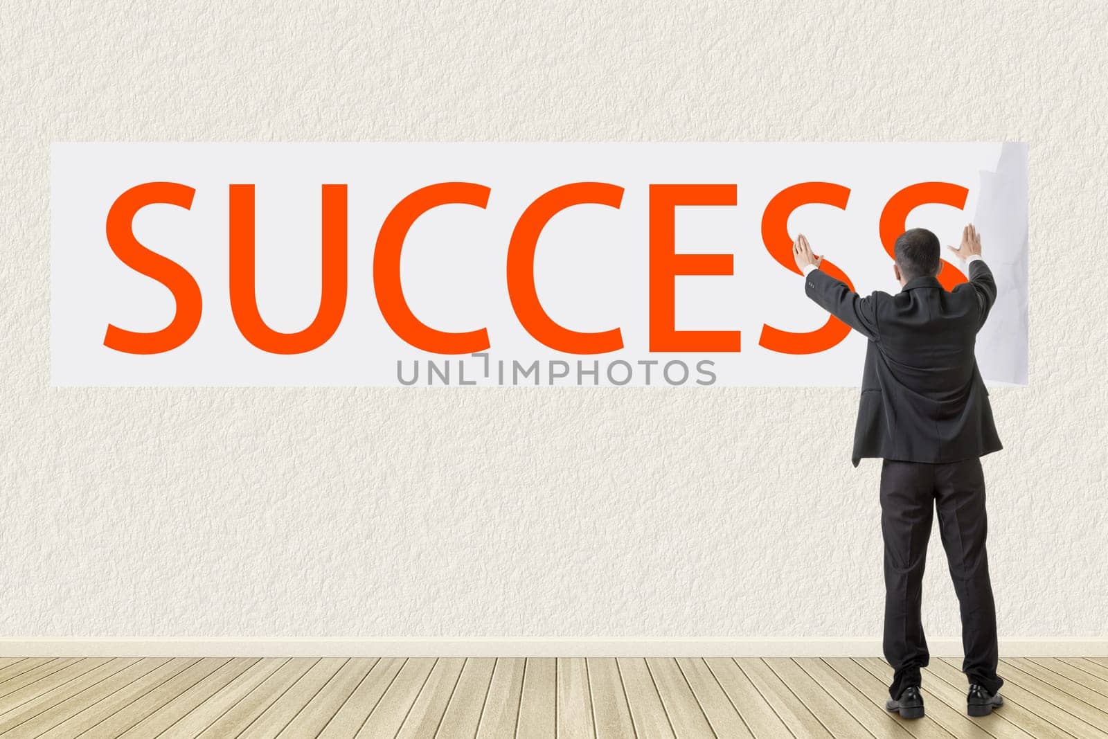 Concept of success, a man post a playbill with text on the wall.