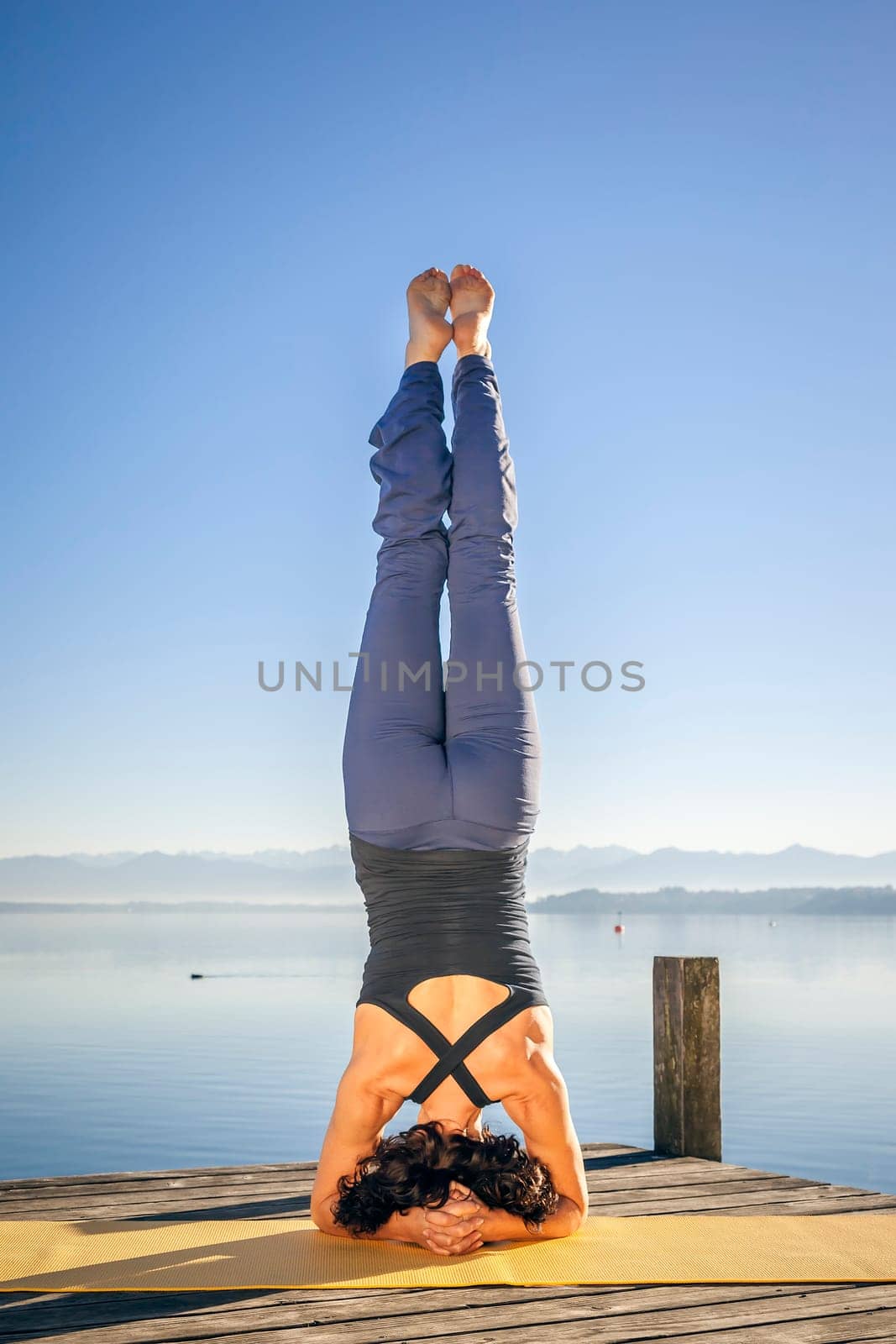 An image of a pretty woman doing yoga at the lake